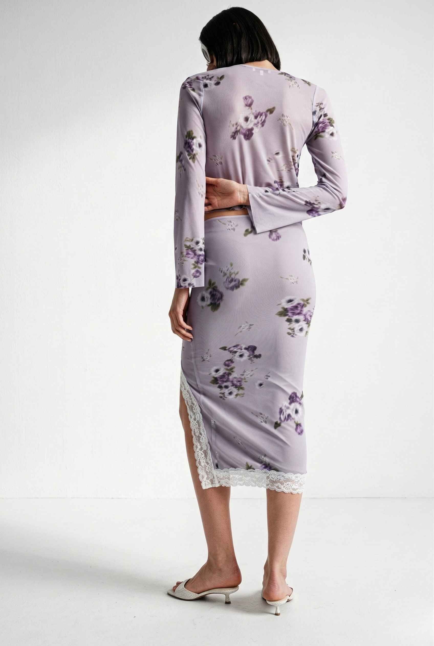 Woman wearing a Elara Top Lavender Floral Lace Trim Fly-Away Cardigan with a white background