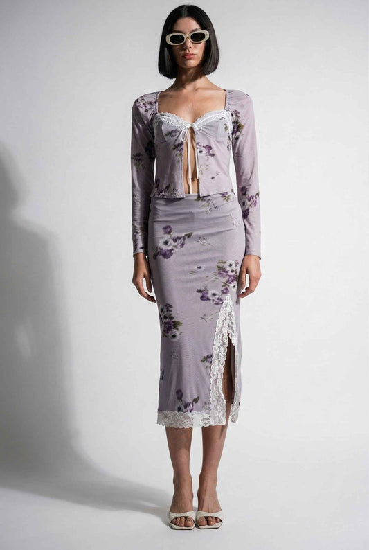 Woman wearing a Elara Top Lavender Floral Lace Trim Fly-Away Cardigan with a sheer overlay against a white background