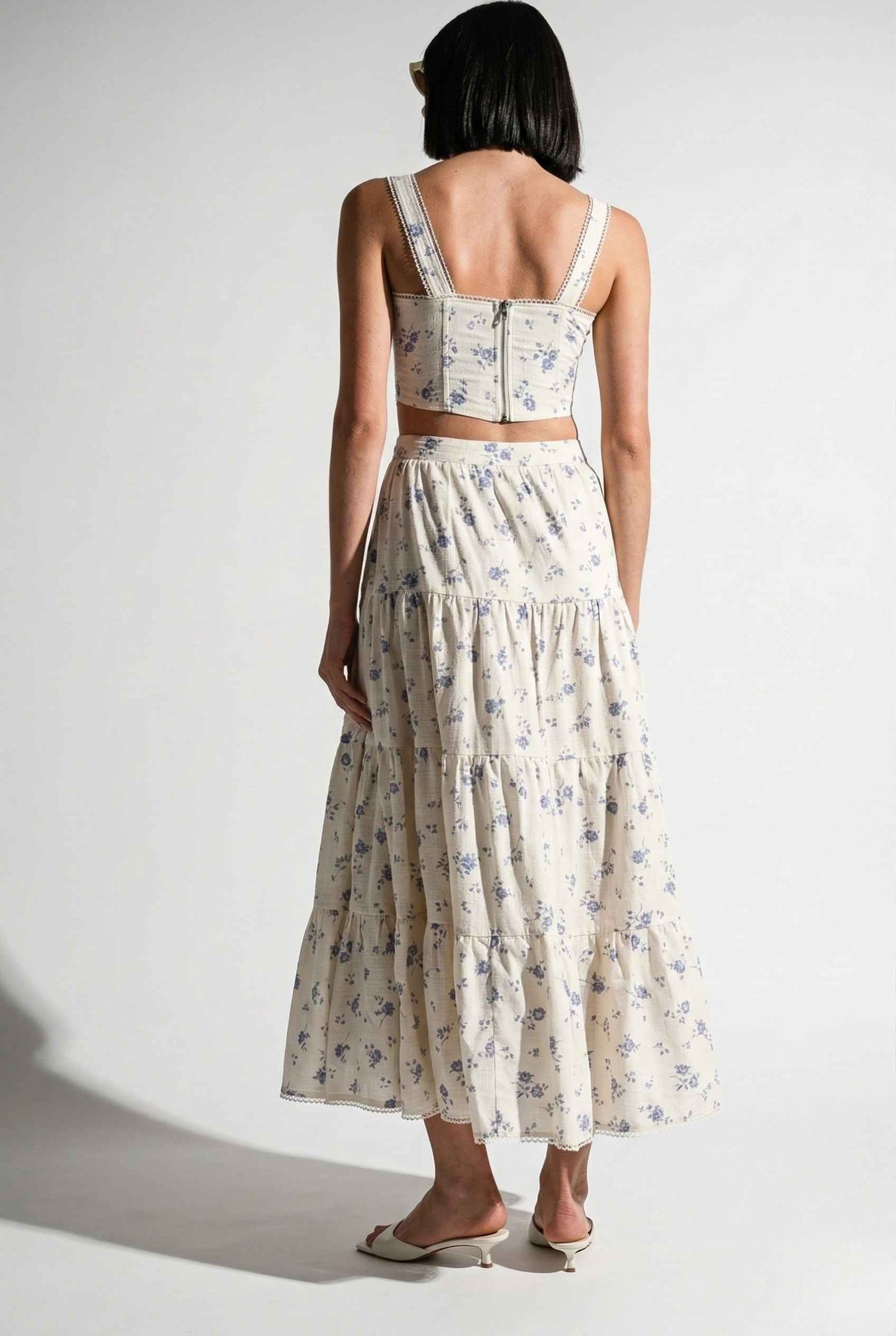 Woman wearing a Eliana Top White & Blue Floral Cotton Corset Crop with a white background