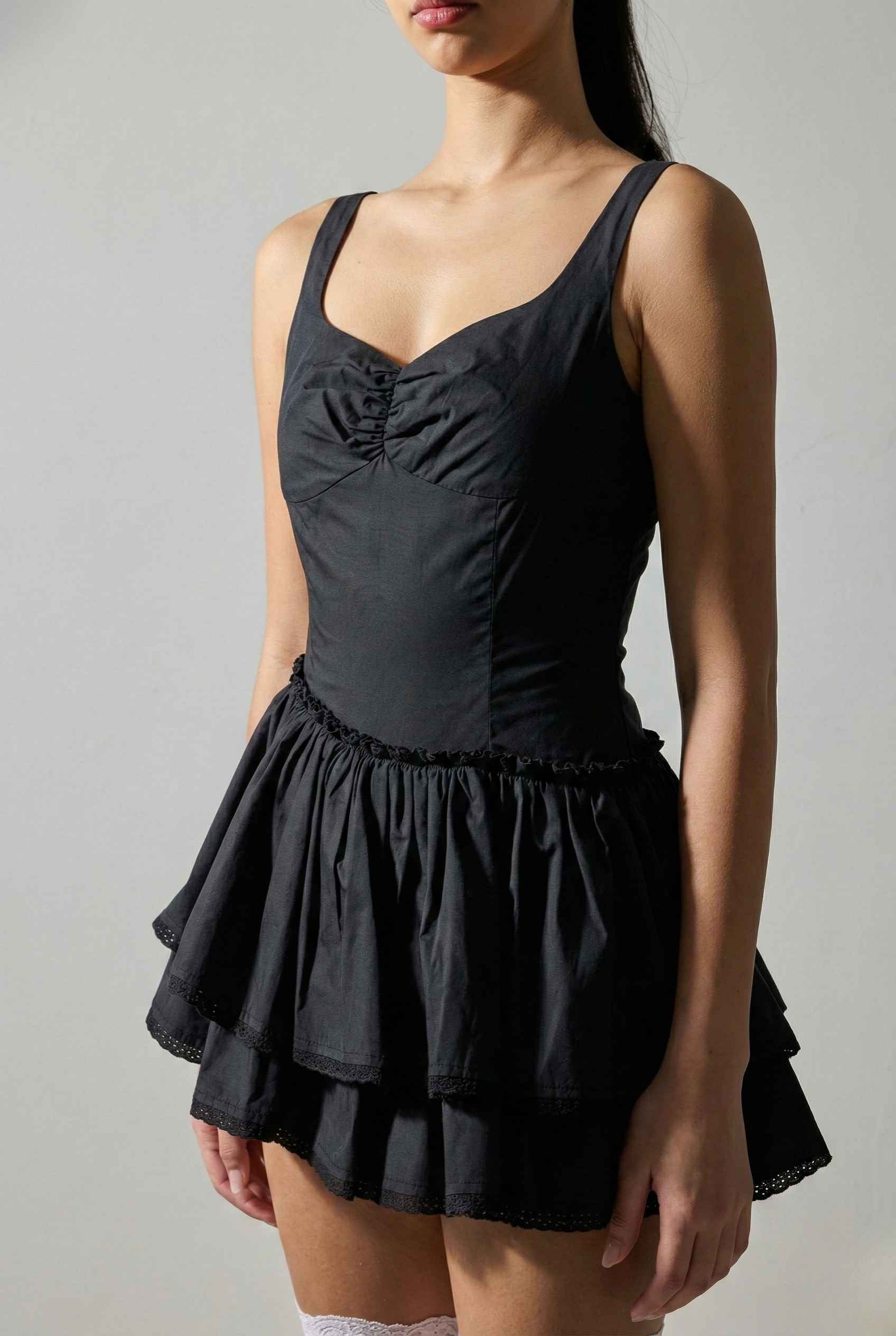 Elodie Mini Black Tiered Ruffle Cotton Mini Dress with ruched bodice worn by a model on a plain background