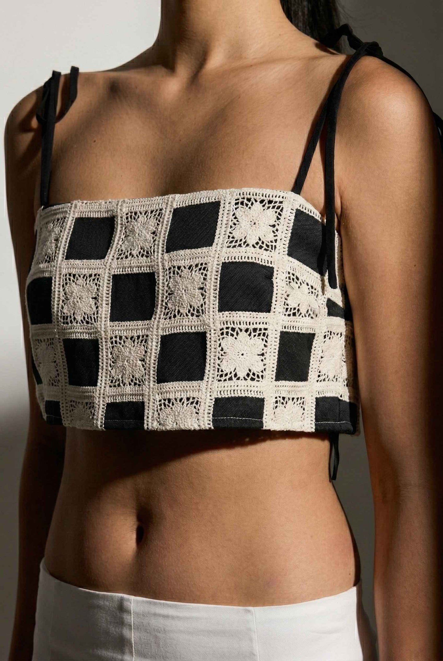 Model wearing Elodie Top in Black Jacquard Square Neck Cami with Ribbon Tie Straps with capri pants  on a plain background