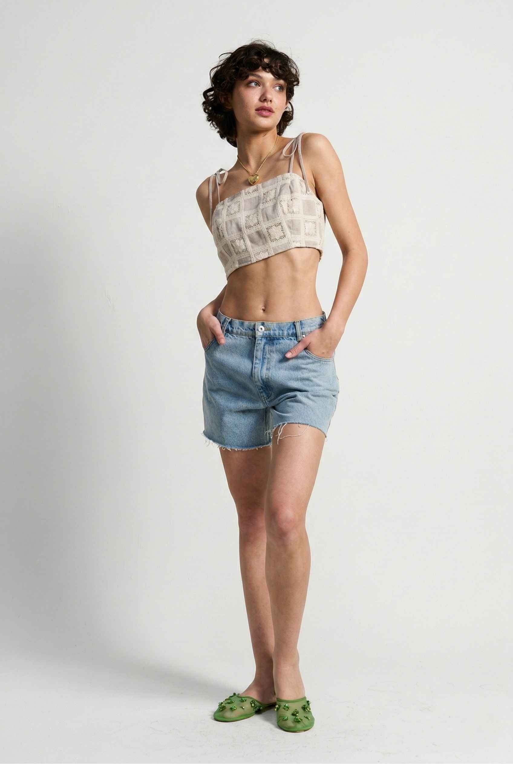 Model wearing Elodie Top in Natural Jacquard Square Neck Cami with Ribbon Tie Straps with denim shorts and slip on shoes on a plain background