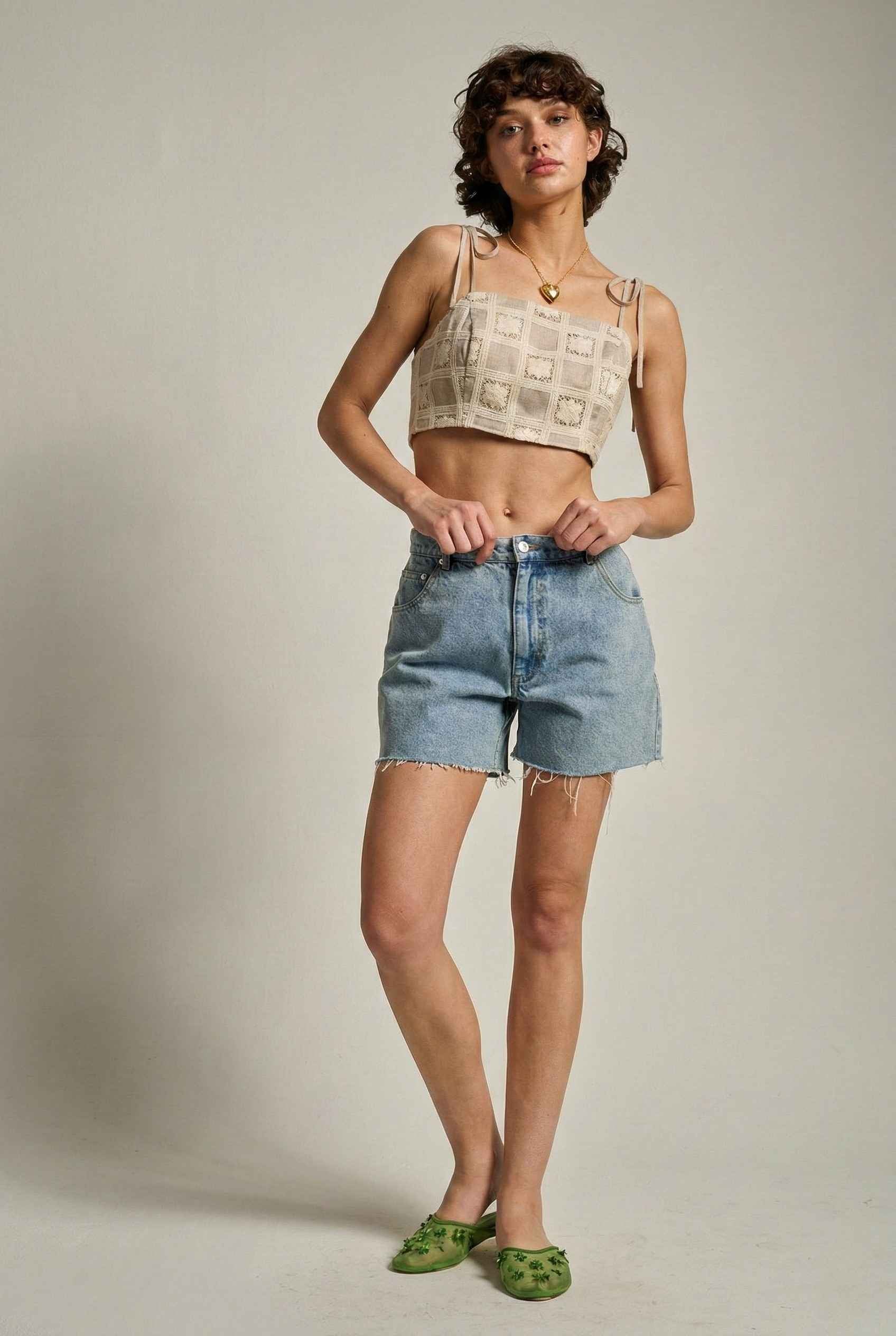 Model wearing Elodie Top in Natural Jacquard Square Neck Cami with Ribbon Tie Straps with denim shorts and slip on shoes on a plain background