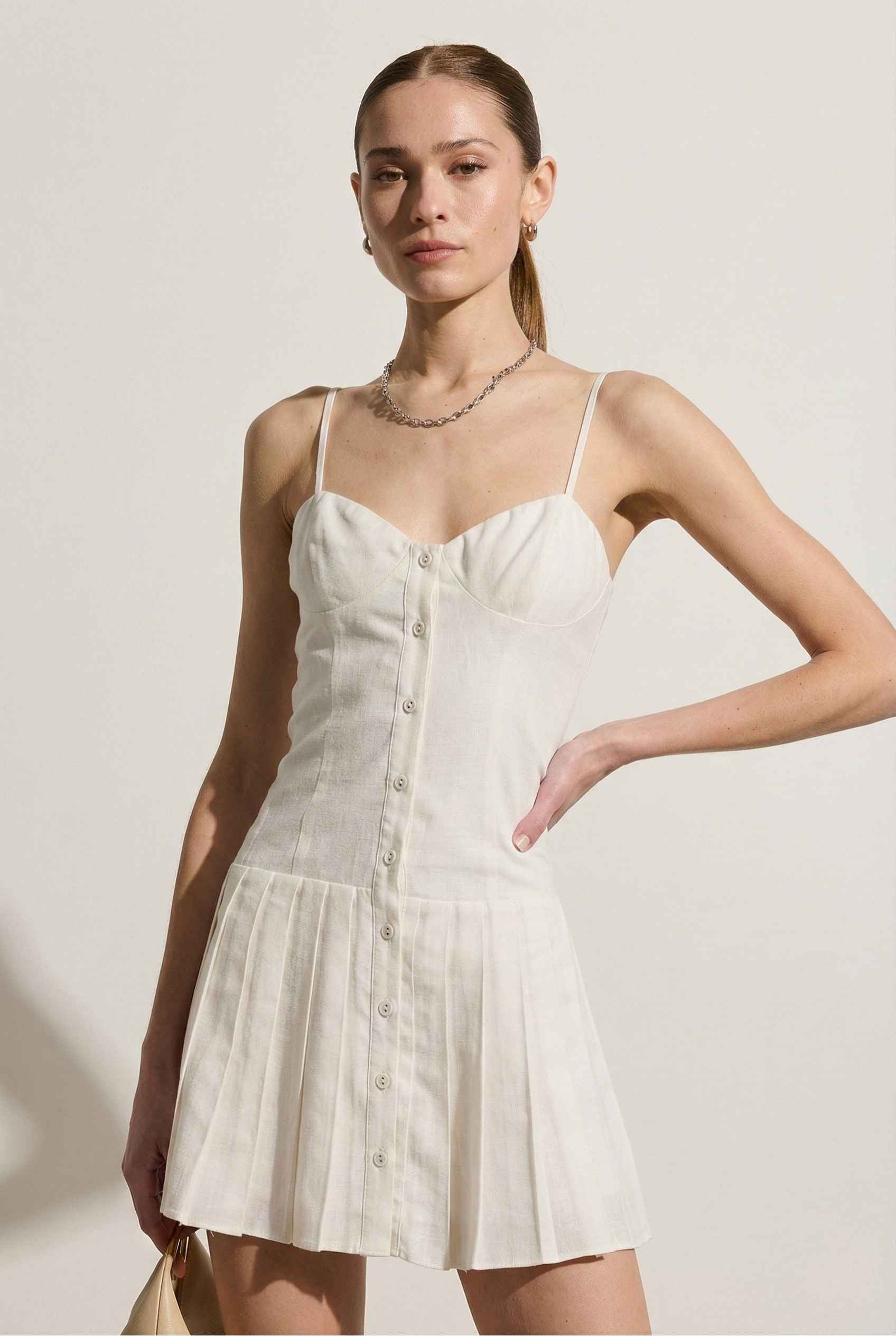Woman wearing a Eloise Mini White Linen Blend Button Front Dress against a plain background