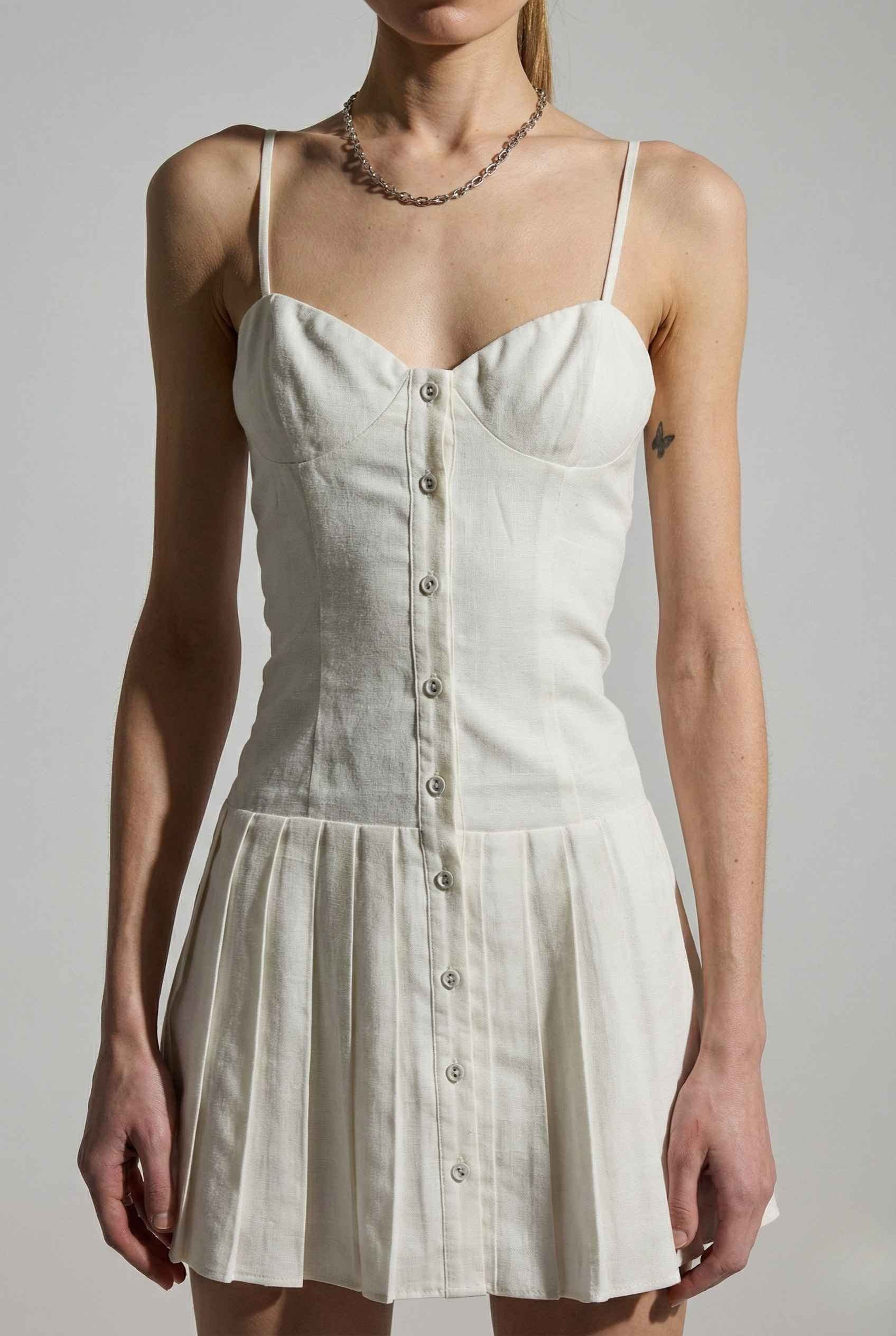 Woman wearing a Eloise Mini White Linen Blend Button Front Dress with buttons on a plain background