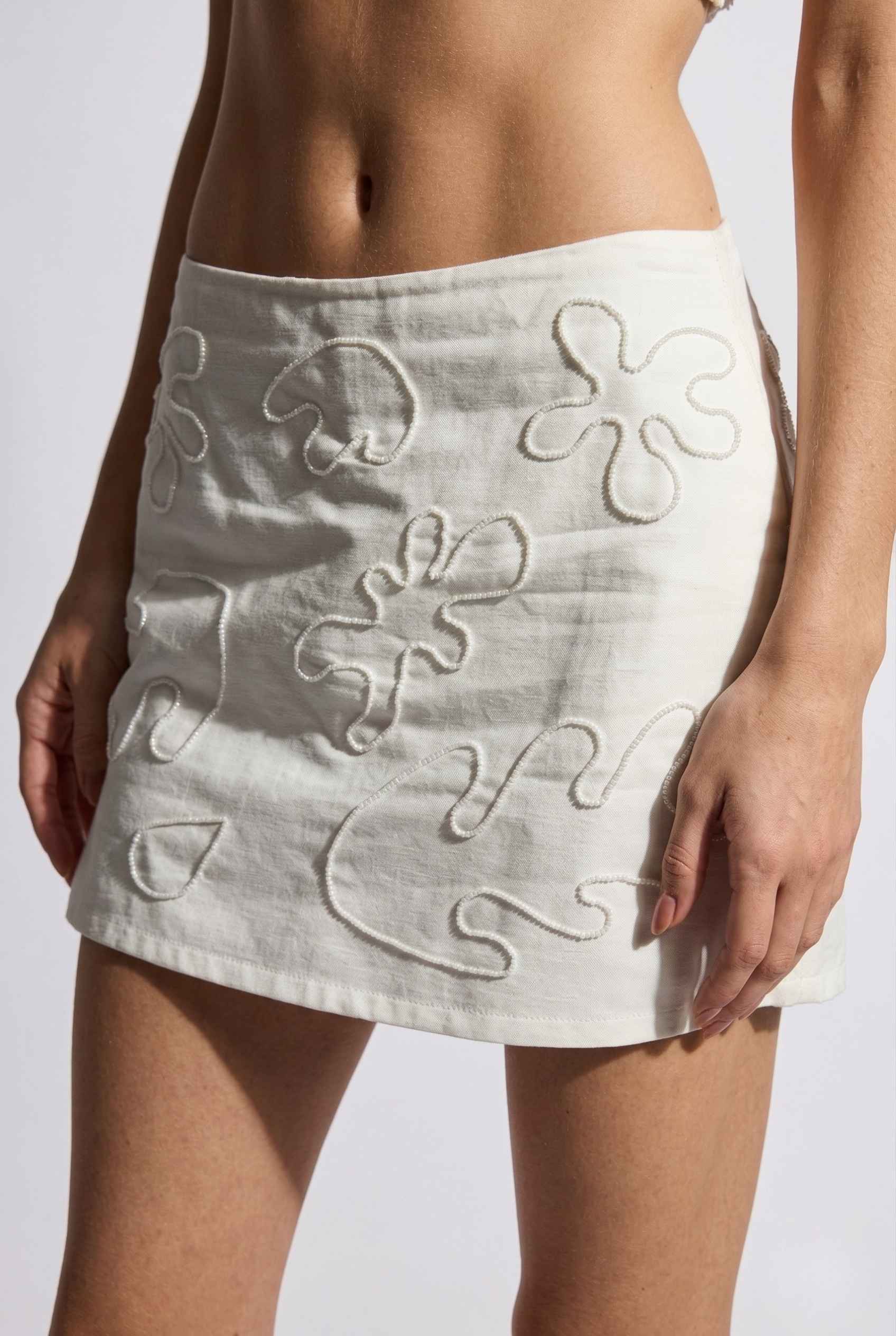 Emory Skort White Tonal Embroidered Cotton-Linen Mini Skort worn by a woman on a plain background