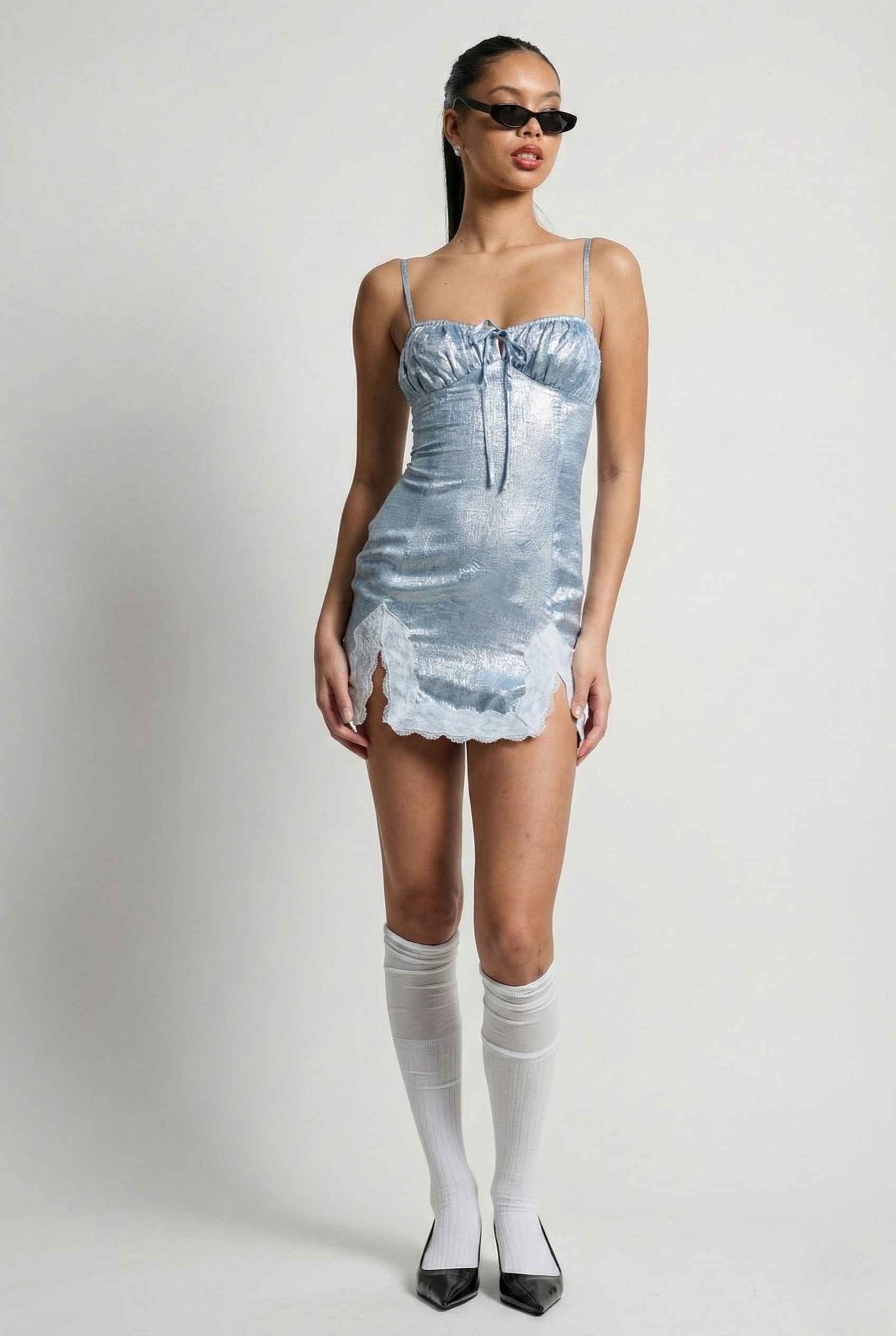 Woman wearing a Esme Mini Light Blue Satin Lace Hem Dress with a textured pattern on a plain background