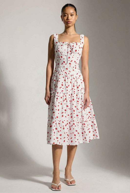 Woman wearing a Felicity Midi Red Strawberry Print Tiered Dress with red floral pattern against a plain background