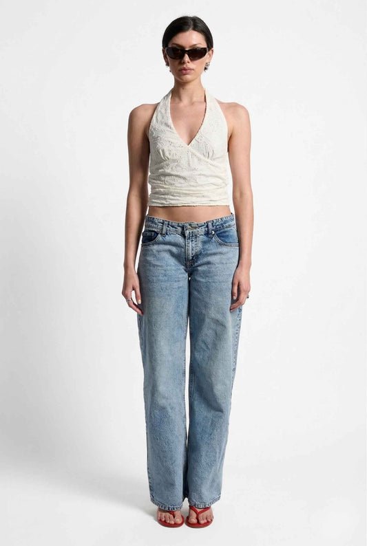 Woman wearing a Freya Top Ivory Floral Lace Wrap Halter Crop on plain background.