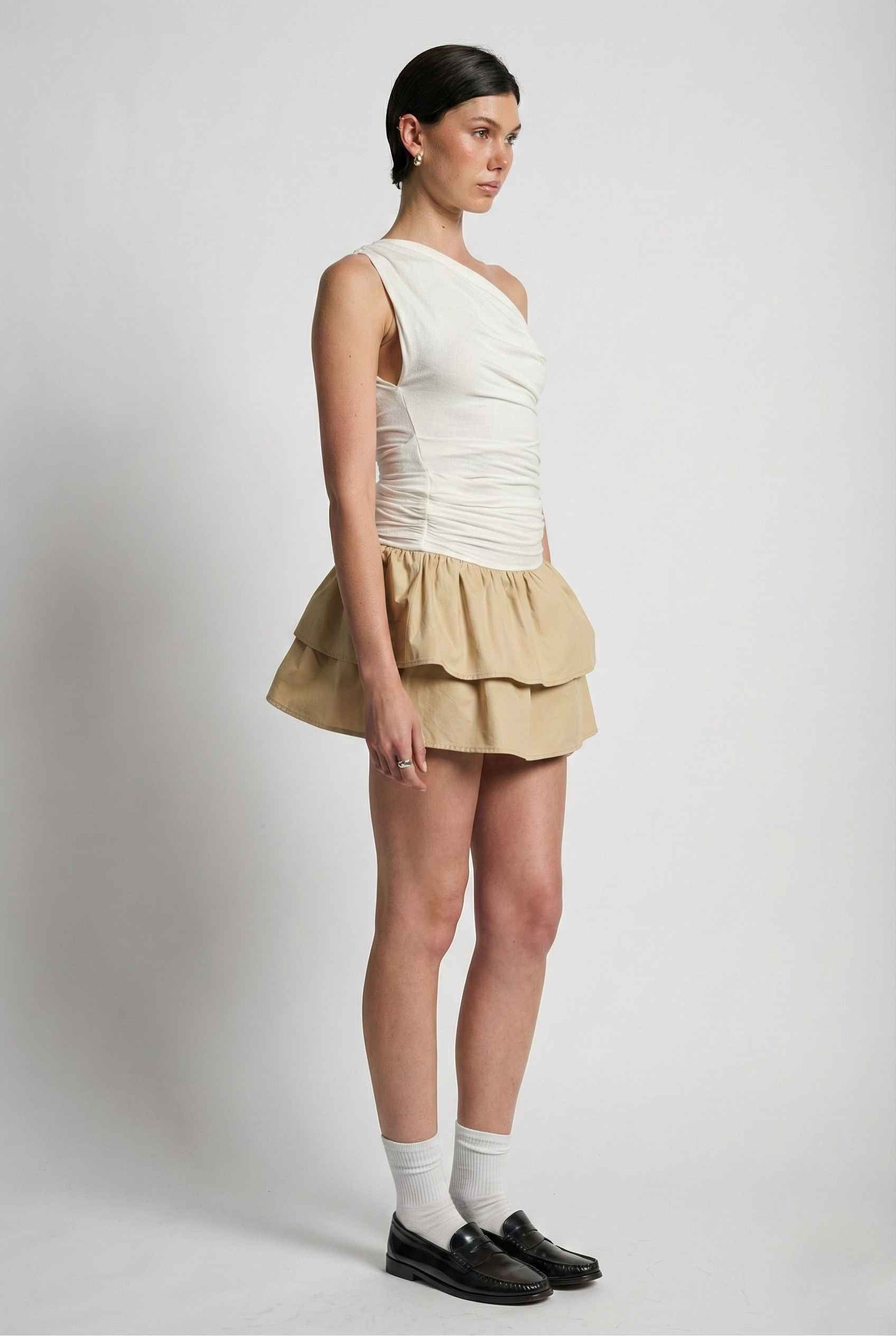 Woman wearing a Hadley Mini Ivory Ruched One-Shoulder Mixed Media Dress on a plain background