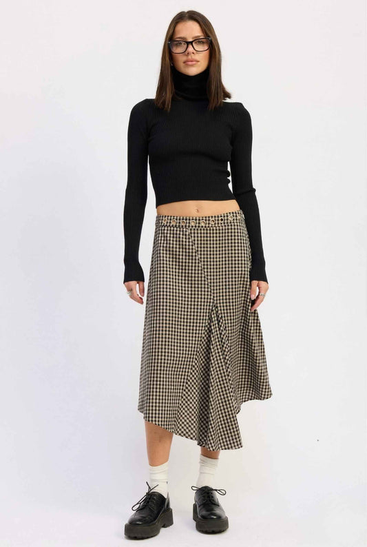 Woman wearing a black long-sleeve top and Hadley Skirt Black Gingham Asymmetrical Midi Skirt with Grommet Waist on a white background