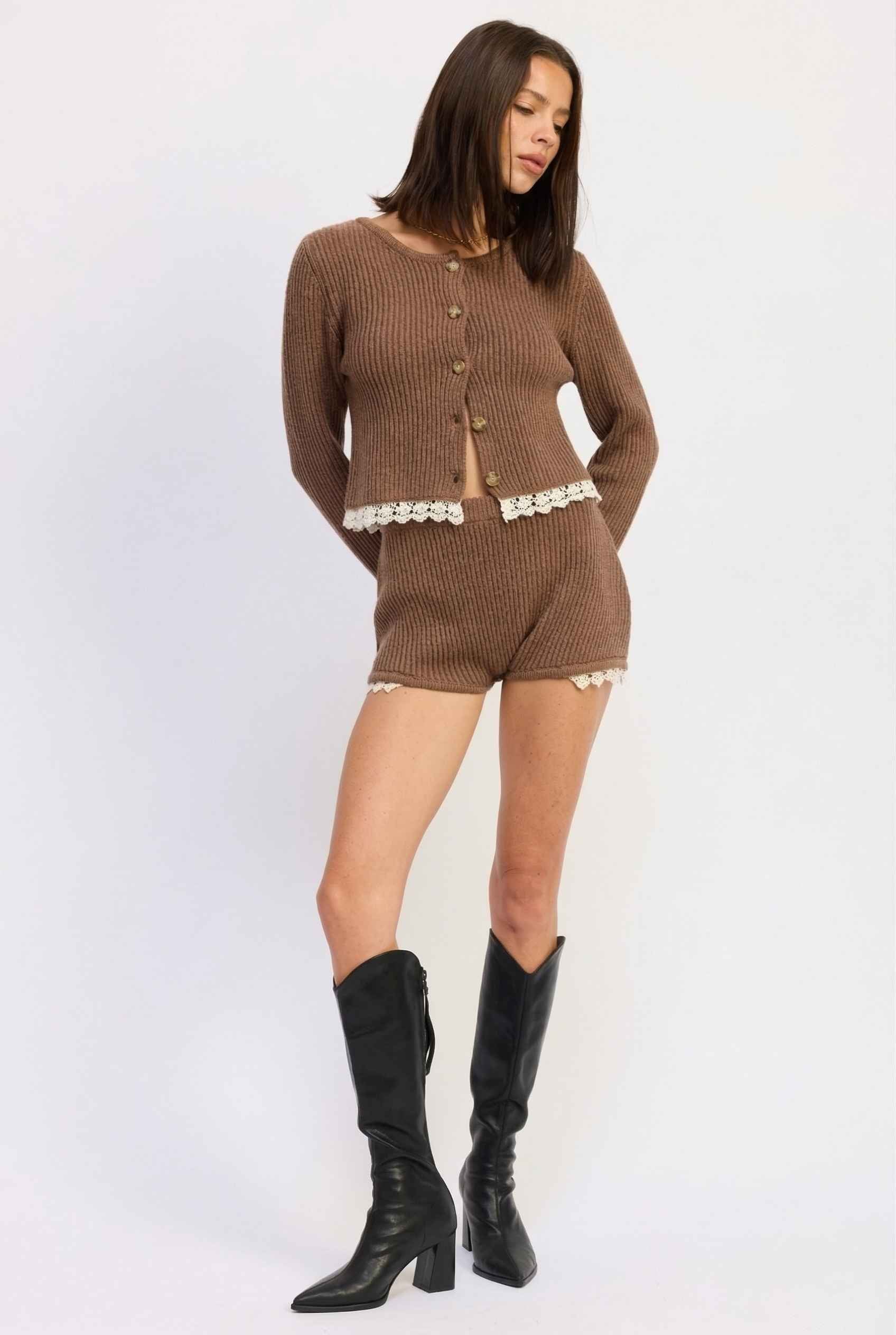 Woman wearing a Hazel Shorts Brown Ribbed Knit Micro Shorts with Lace Trim with black knee-high boots on a white background