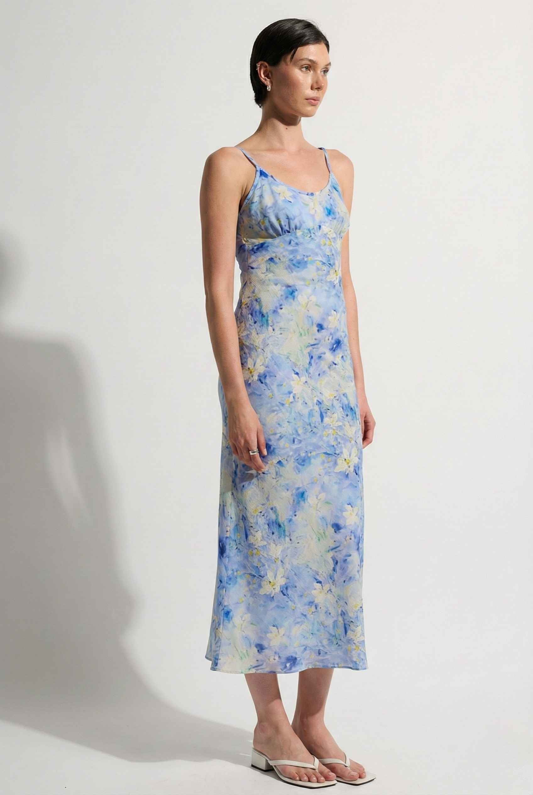 Woman wearing a Iris Midi Light Blue Floral Satin Slip Dress against a white background