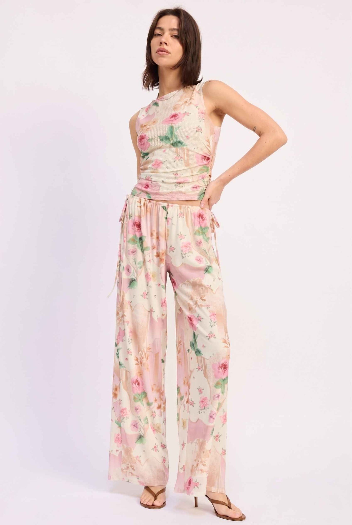 Model wearing Isabella Floral Wide-Leg Pants in Rose Floral High-Waist Trousers paired with matching high-neck tank top and heeled sandals