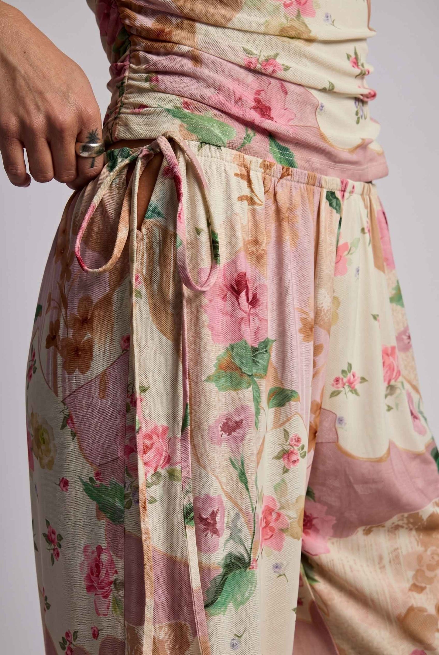 Model wearing Isabella Floral Wide-Leg Pants in Rose Floral High-Waist Trousers paired with matching high-neck tank top close up unique floral pattern