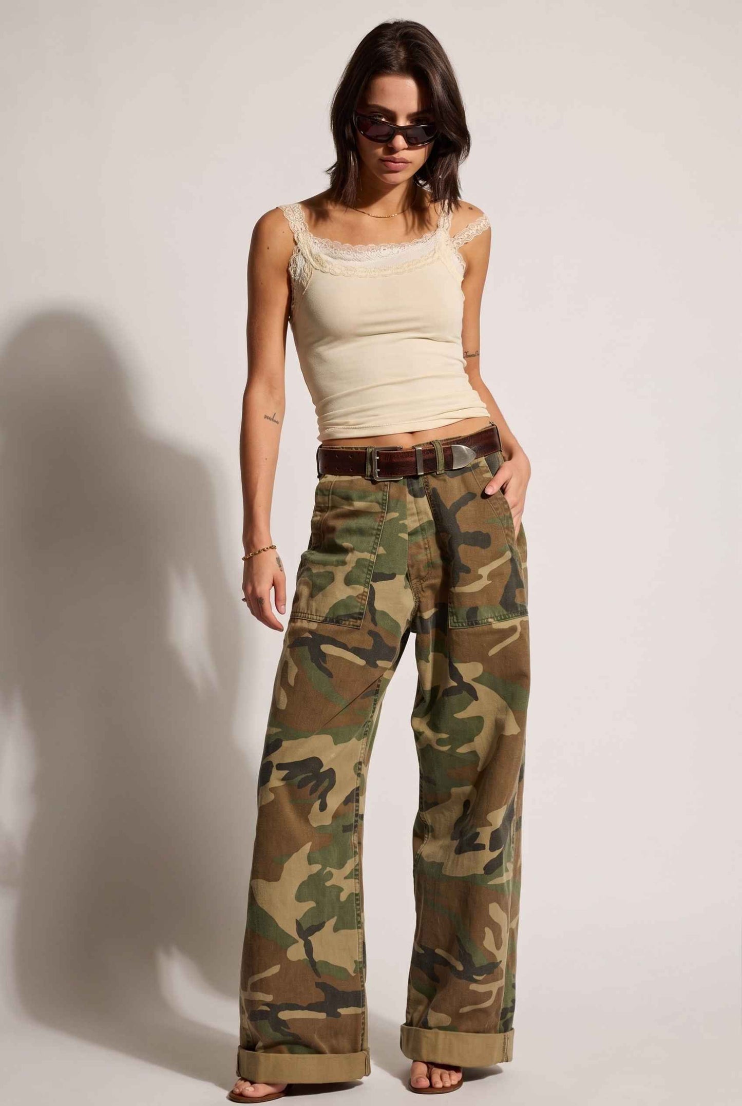 Model wearing Isabella Layered Lace Cami in Butter Yellow Lace Trim Tank Top paired with camo cargo pants and sandals