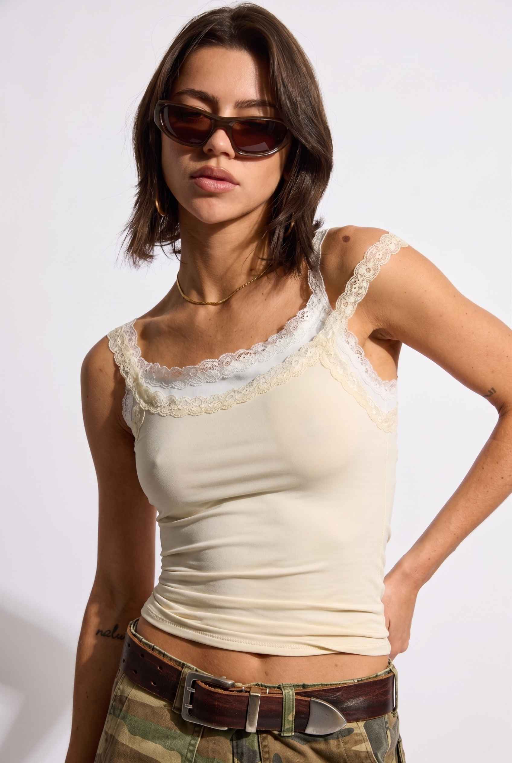 Model wearing Isabella Layered Lace Cami in Butter Yellow Lace Trim Tank Top paired with camo cargo pants 