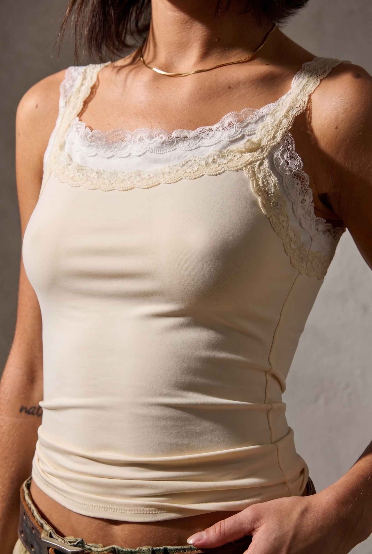 Model wearing Isabella Layered Lace Cami in Butter Yellow Lace Trim Tank Top paired with camo cargo pants close up lace layered detail
