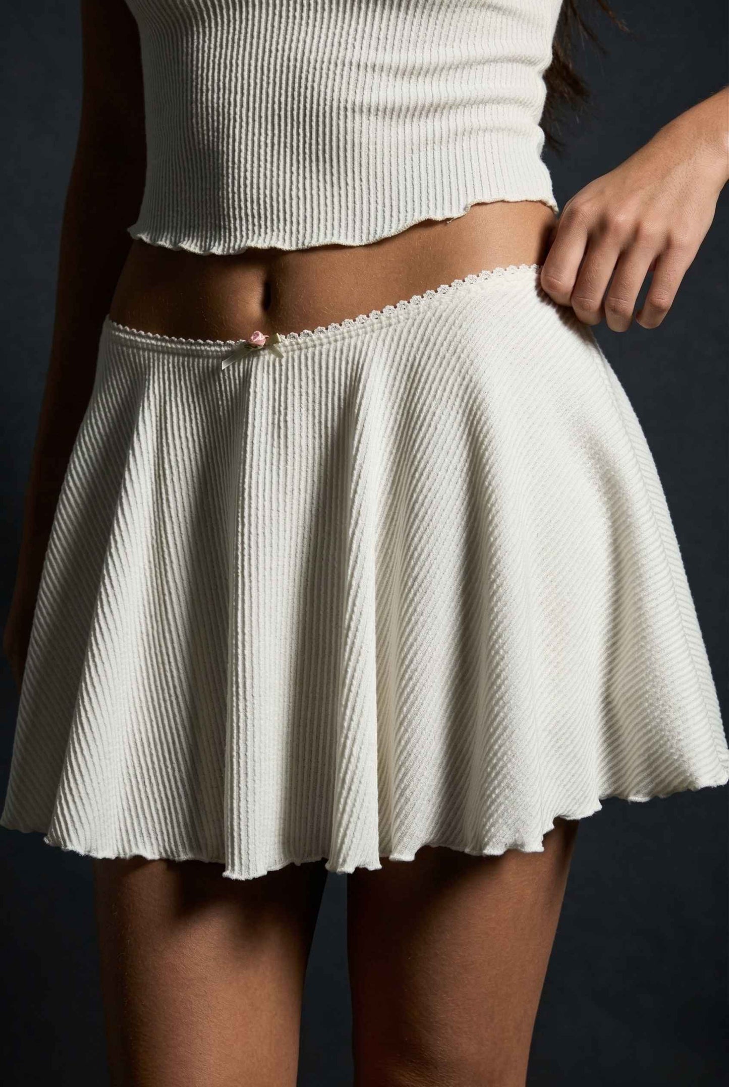 Ivy Skirt White Textured Knit Circle Mini Skirt with Bow worn by a woman on a dark background
