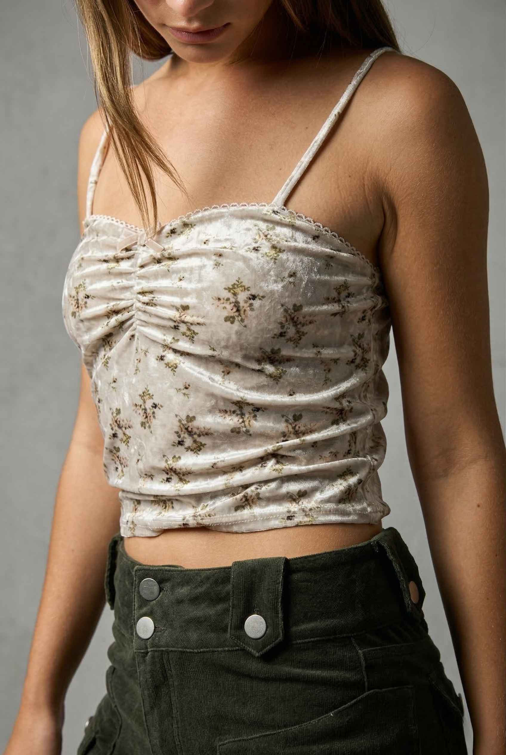Woman wearing a Ivy Top Ivory Floral Crushed Velvet Lace Trim Cami with floral details against a gray background