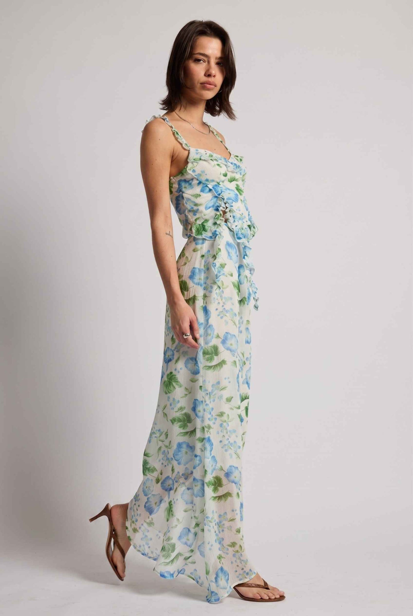 Model wearing  Julia Asymmetrical Floral Bustier Top Ruffle Trim Top in Blue paired with matching maxi skirt and simple heeled sandals