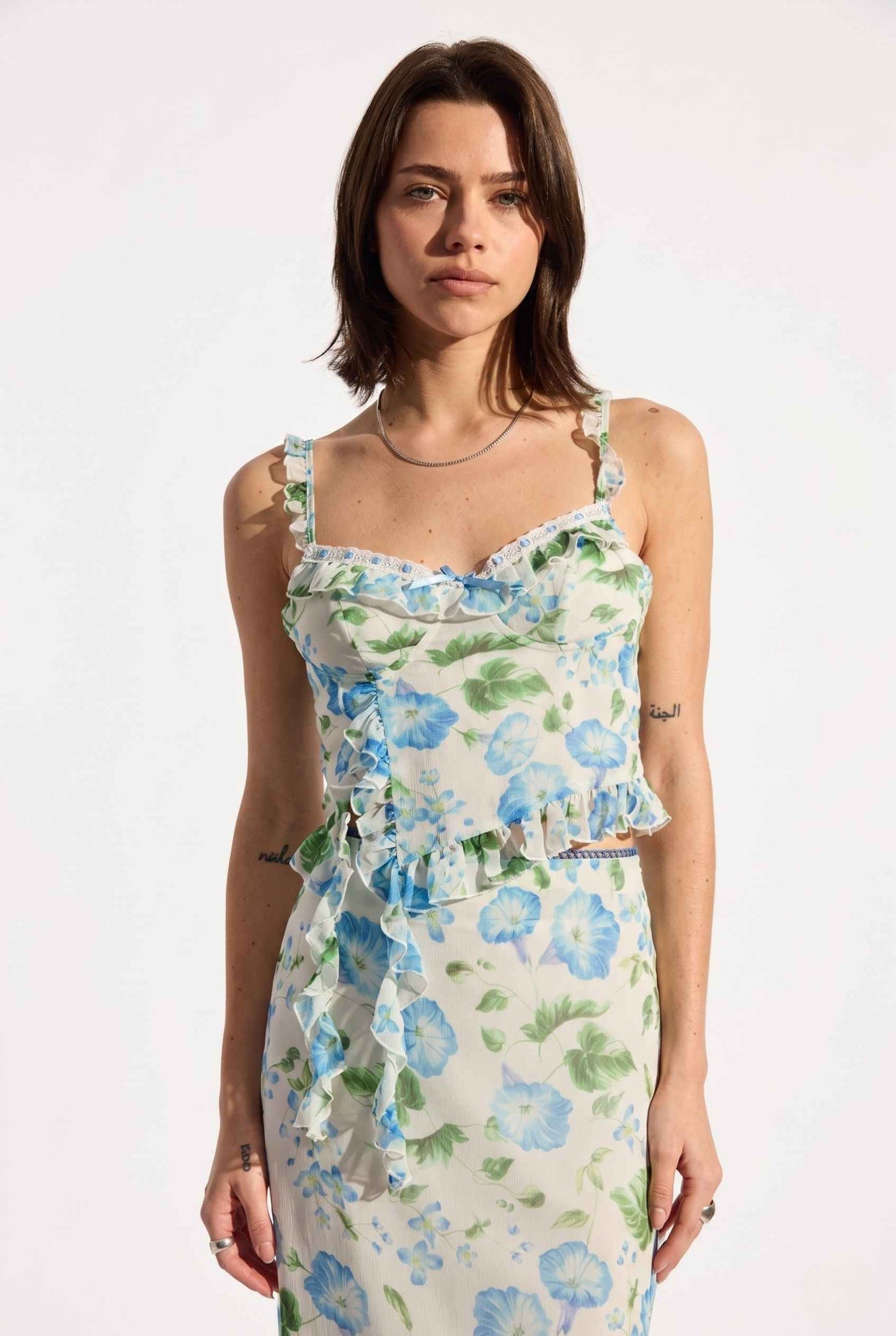 Model wearing  Julia Asymmetrical Floral Bustier Top Ruffle Trim Top in Blue paired with matching maxi skirt close up ruffle trim