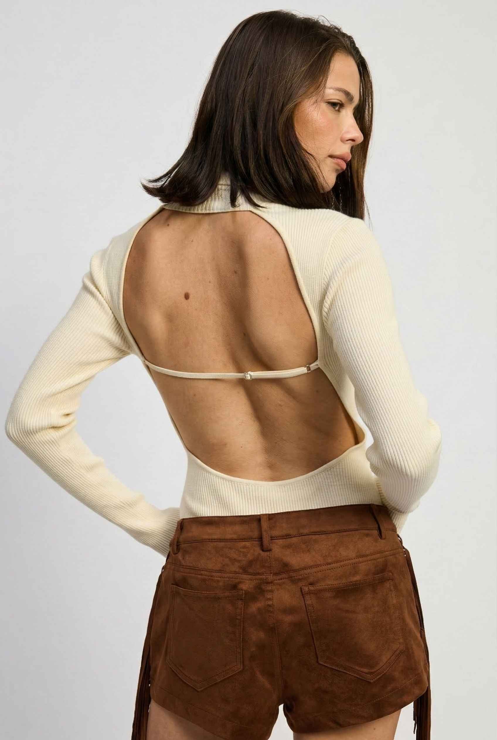 Model wearing Kiera Bodysuit Ribbed Knit Turtleneck Long Sleeve Bodysuit in Ivory with suede shorts