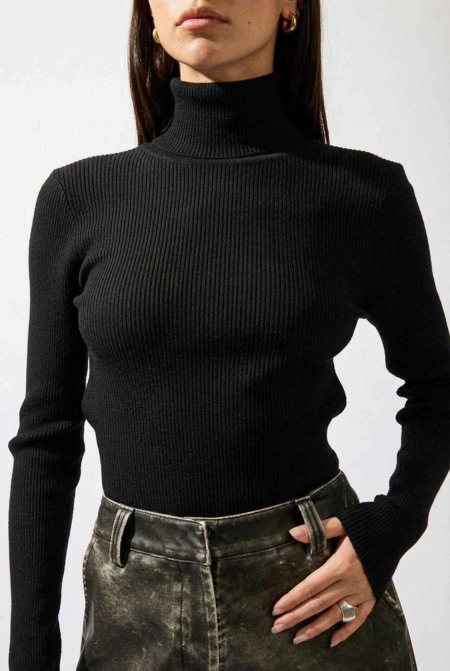 Model wearing Kiera Bodysuit Ribbed Knit Turtleneck Long Sleeve Bodysuit in Black with leather shorts