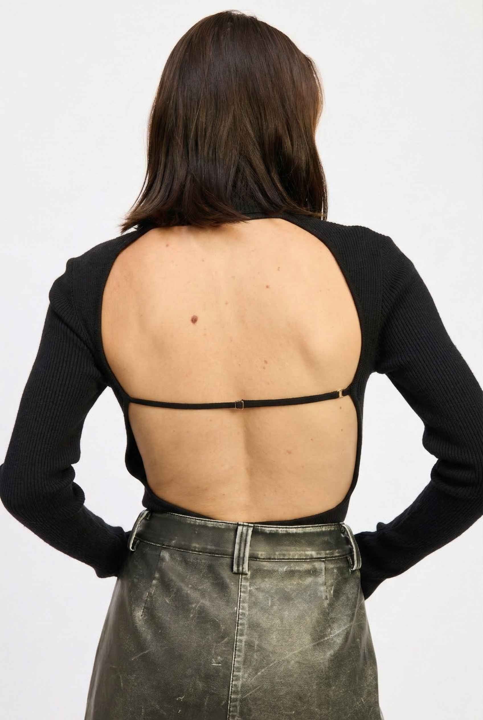 Model wearing Kiera Bodysuit Ribbed Knit Turtleneck Long Sleeve Bodysuit in Black with leather shorts 
