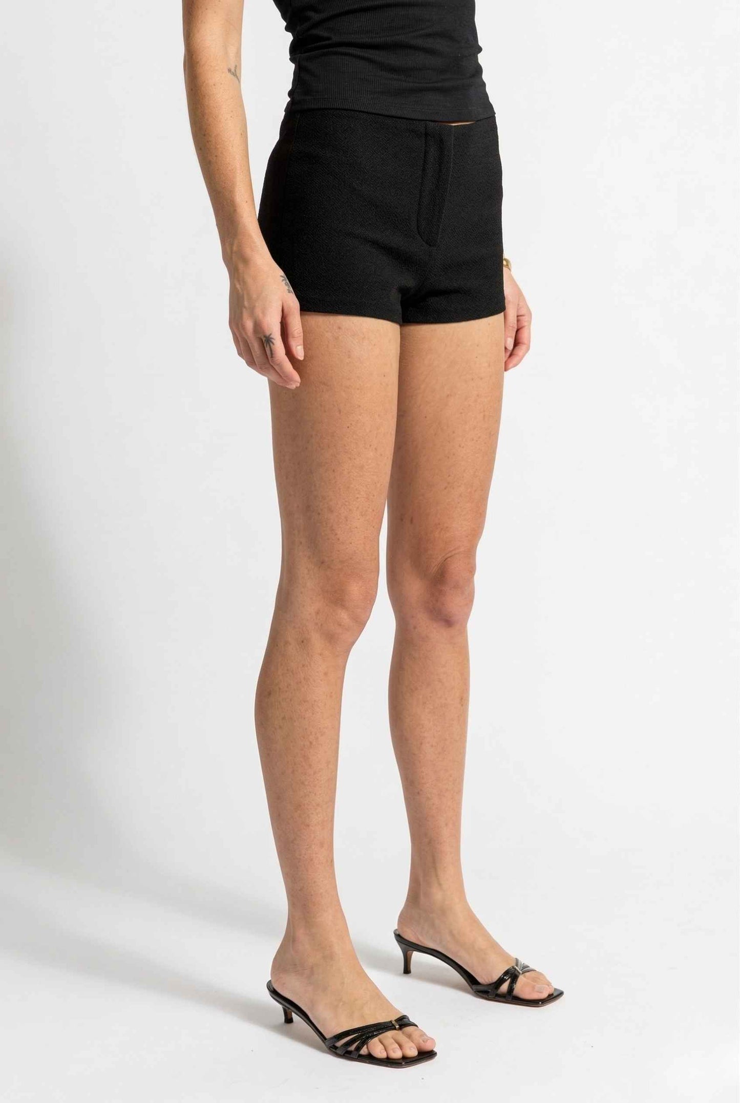 Woman wearing Kyra Shorts Black Rayon-Blend Knit Micro Biker Shorts on a white background