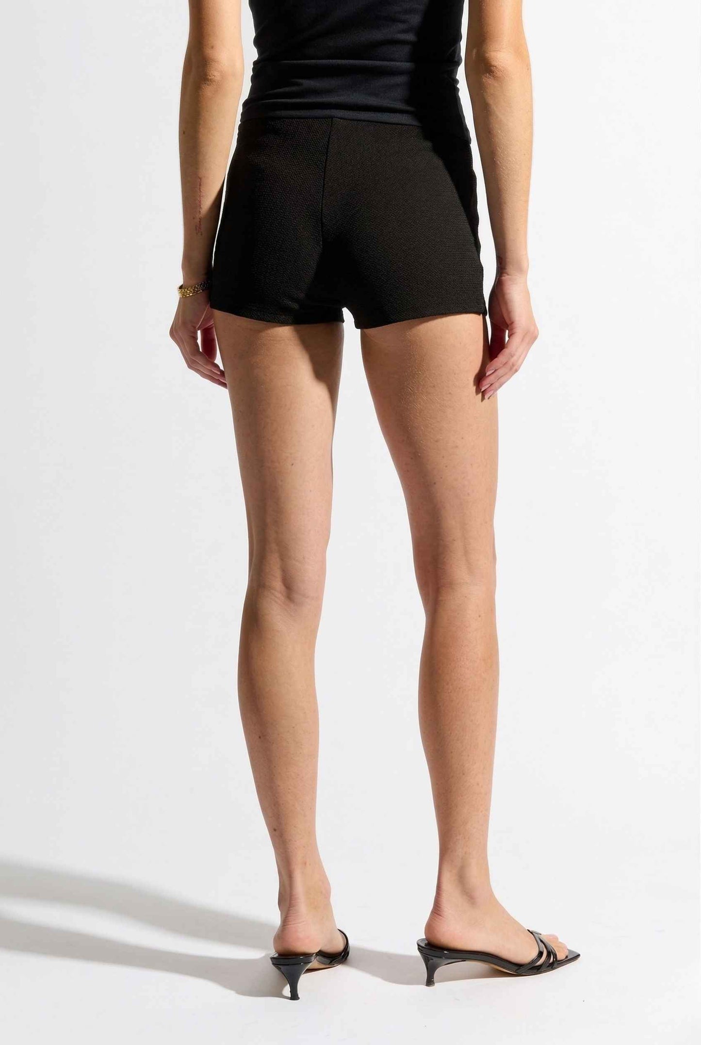 Woman wearing Kyra Shorts Black Rayon-Blend Knit Micro Biker Shorts on a white background