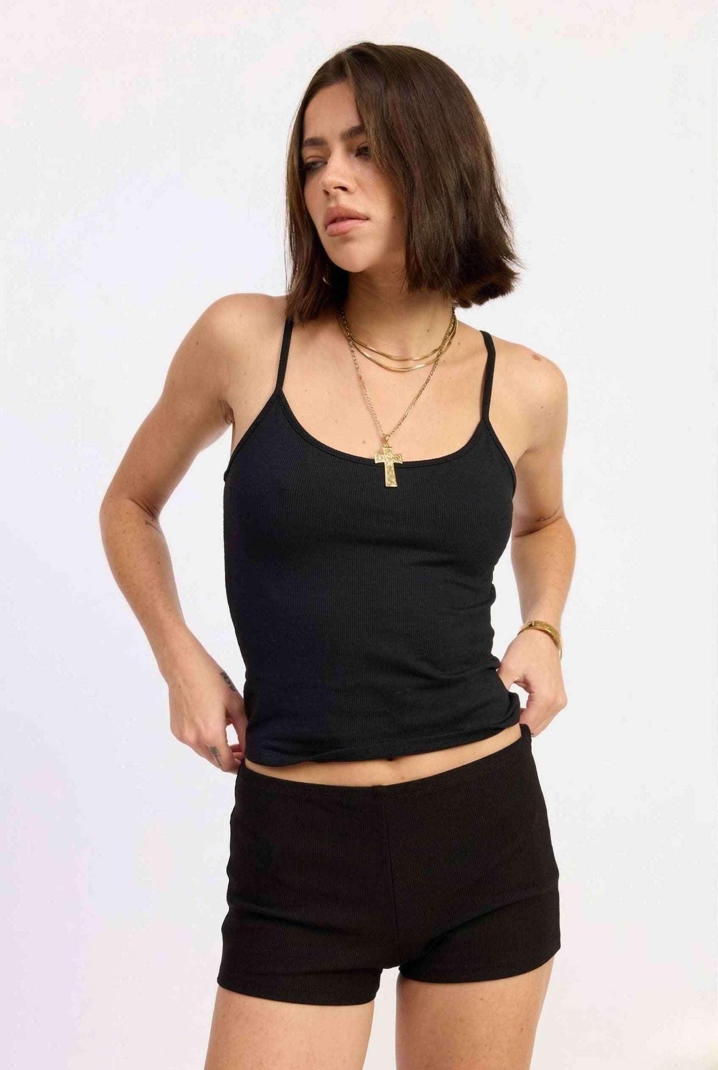 Woman wearing a black tank top and Kyra Shorts Black Rayon-Blend Knit Micro Biker Shorts on a white background