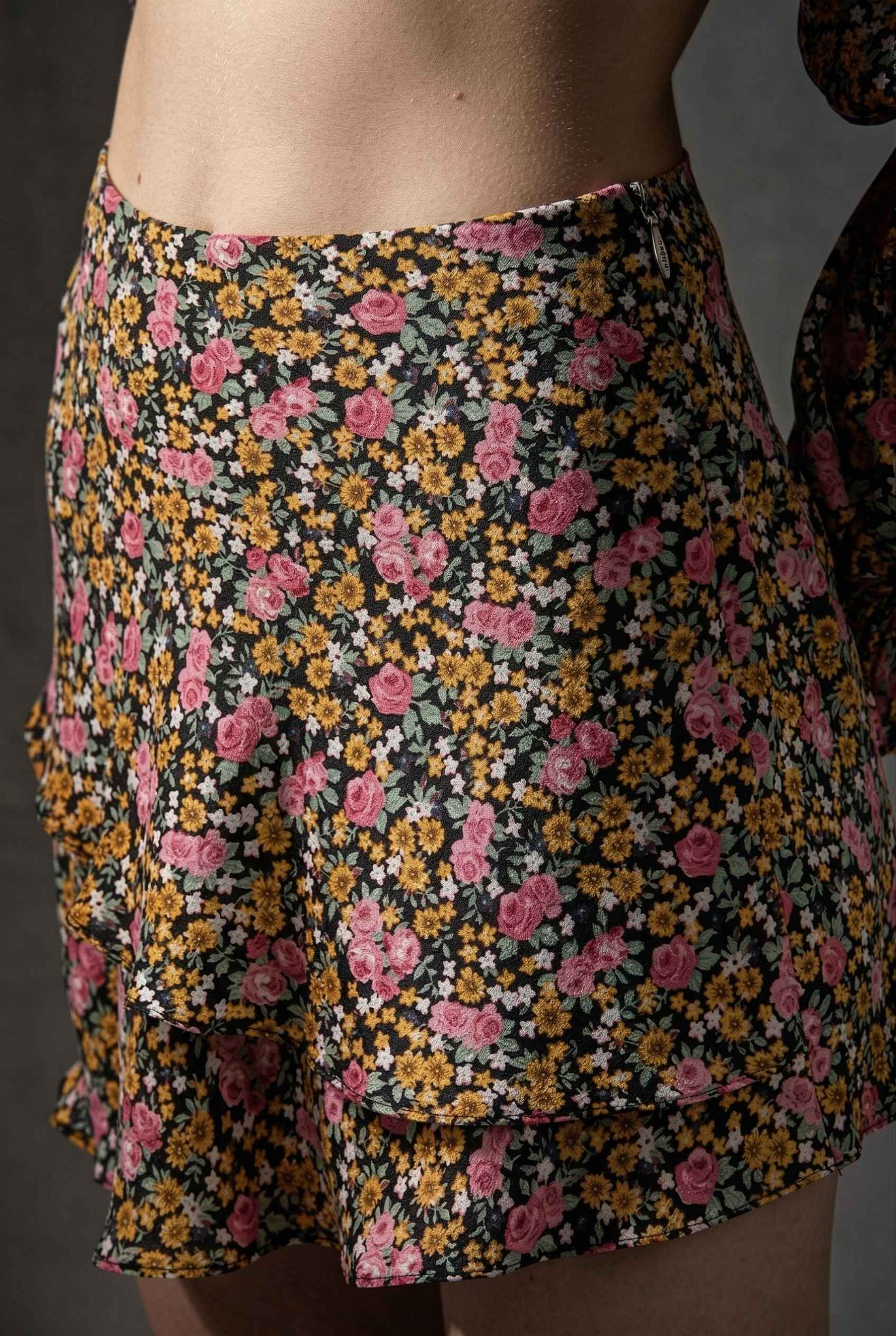 Lyla Skort Black Ditsy Floral Linen-Blend Ruffle Mini Skort worn by a woman against a dark background