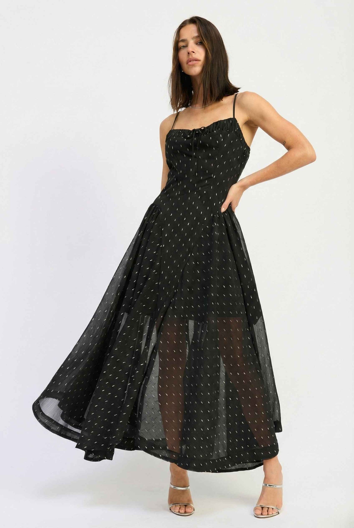 Woman wearing a Lyra Maxi Black Metallic Fleck Chiffon Dress on a white background