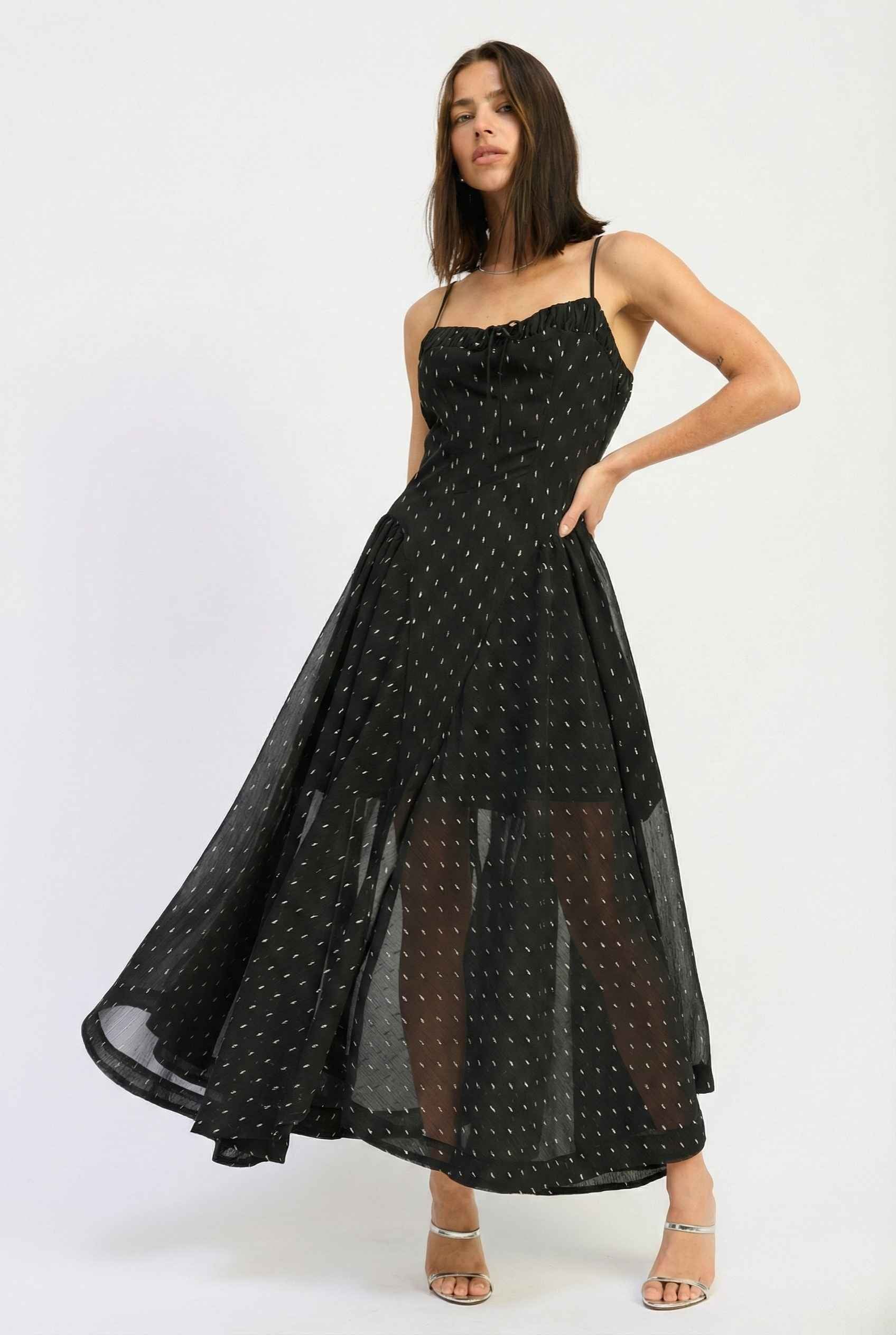 Woman wearing a Lyra Maxi Black Metallic Fleck Chiffon Dress on a white background