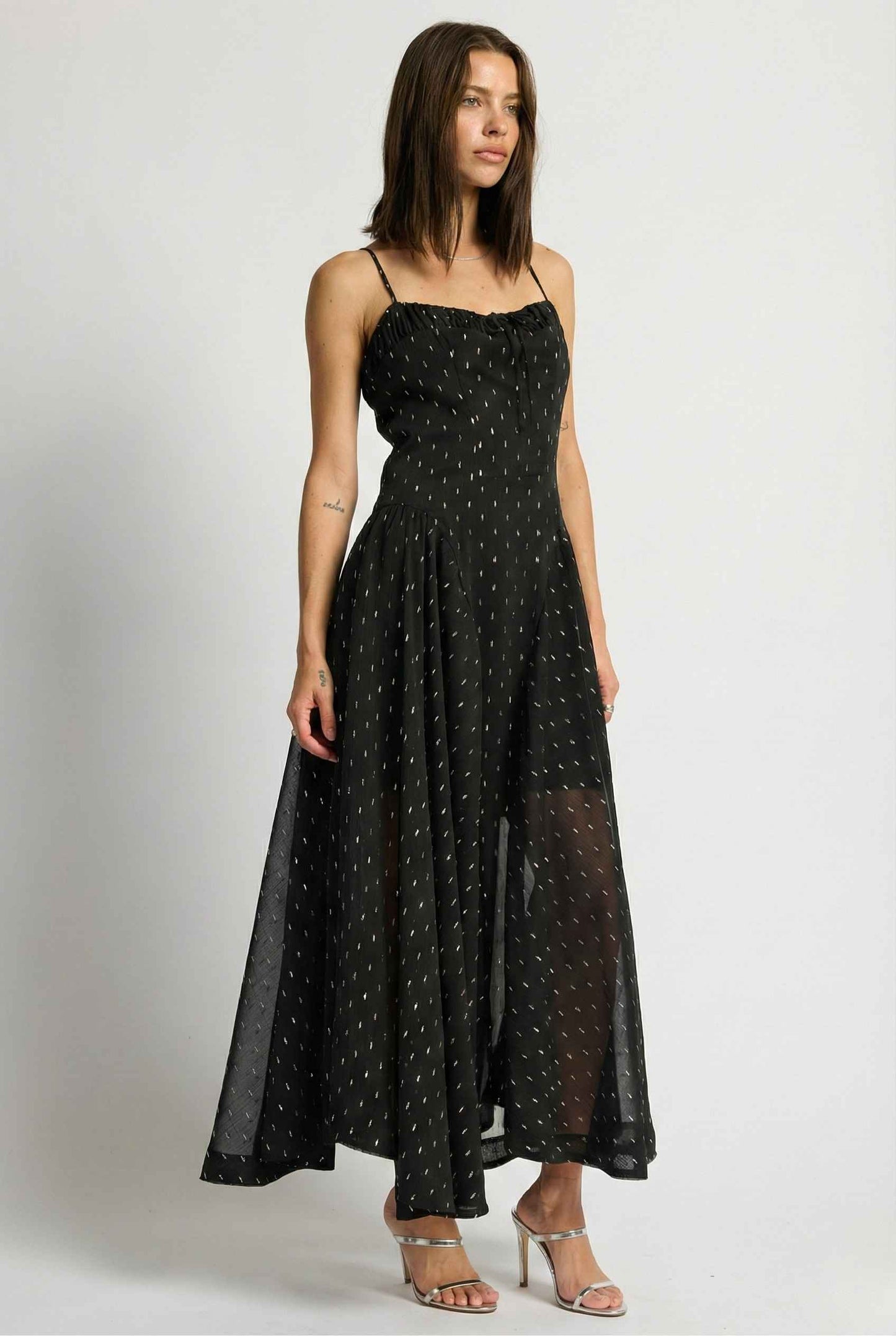 Woman wearing a Lyra Maxi Black Metallic Fleck Chiffon Dress on a white background