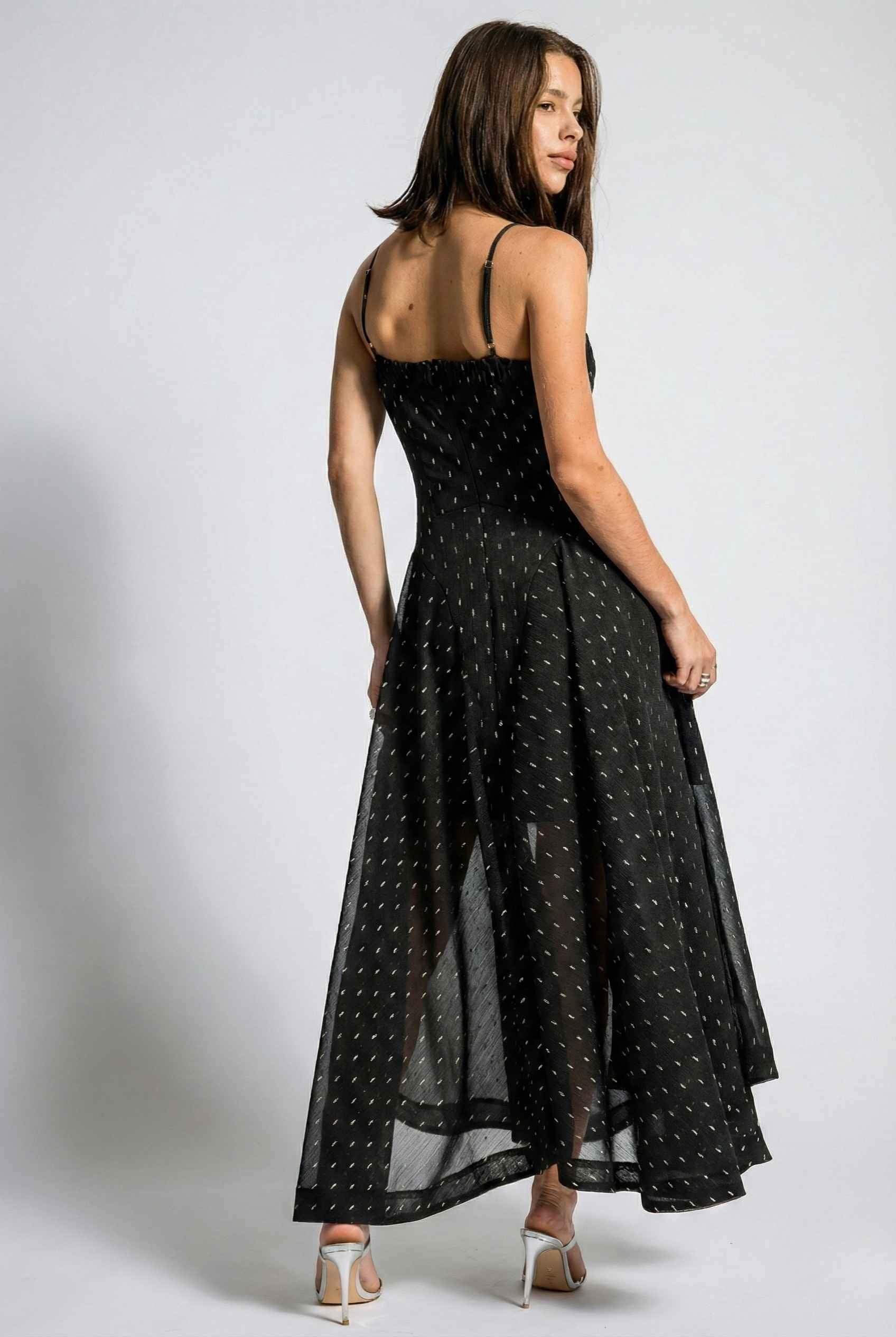 Woman wearing a Lyra Maxi Black Metallic Fleck Chiffon Dress on a white background