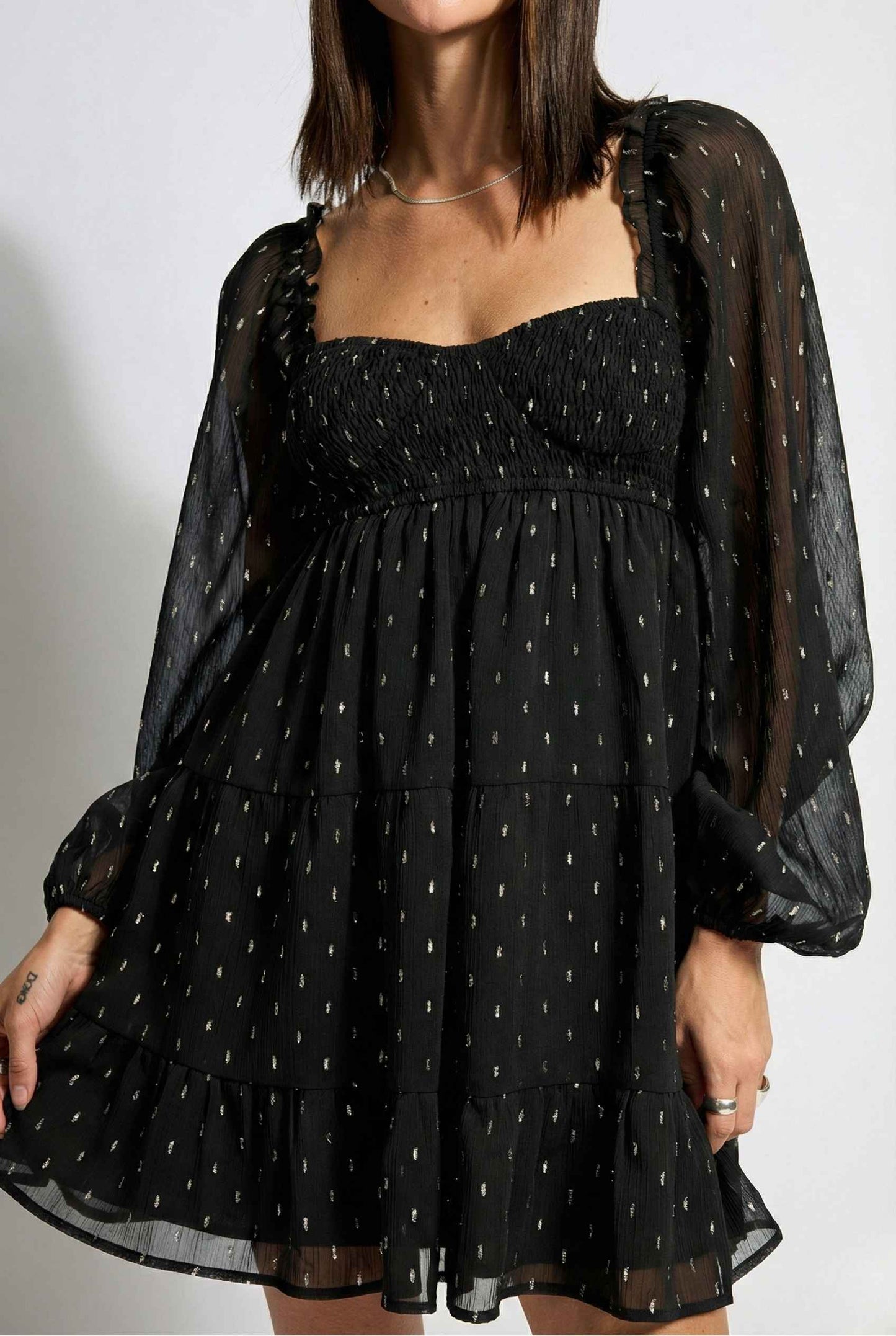 Lyra Mini Black Smocked Long Sleeve Dress with sheer sleeves on a white background