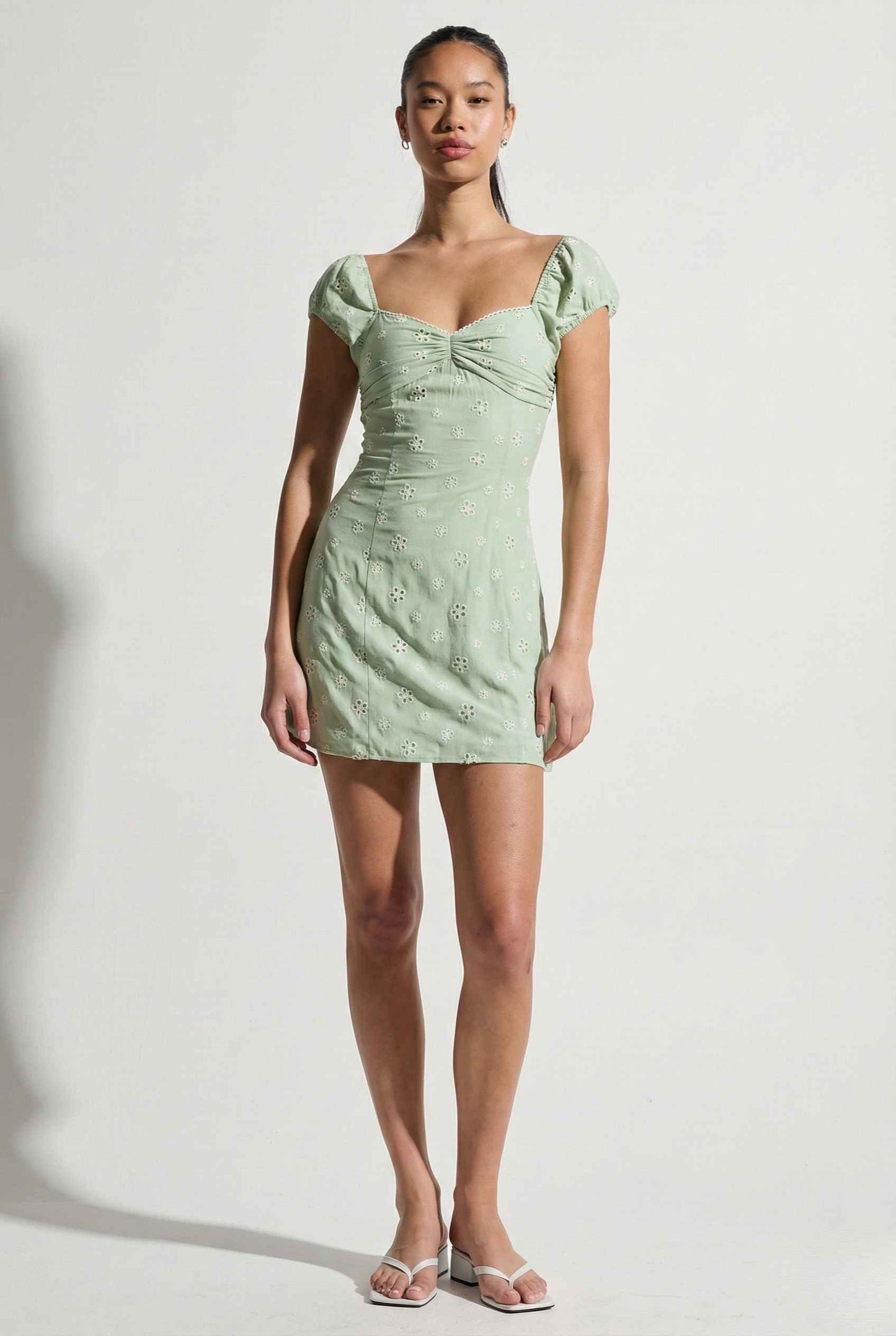 Woman wearing a Maeve Mini Mint Eyelet Ruched Puff Sleeve Dress against a white background