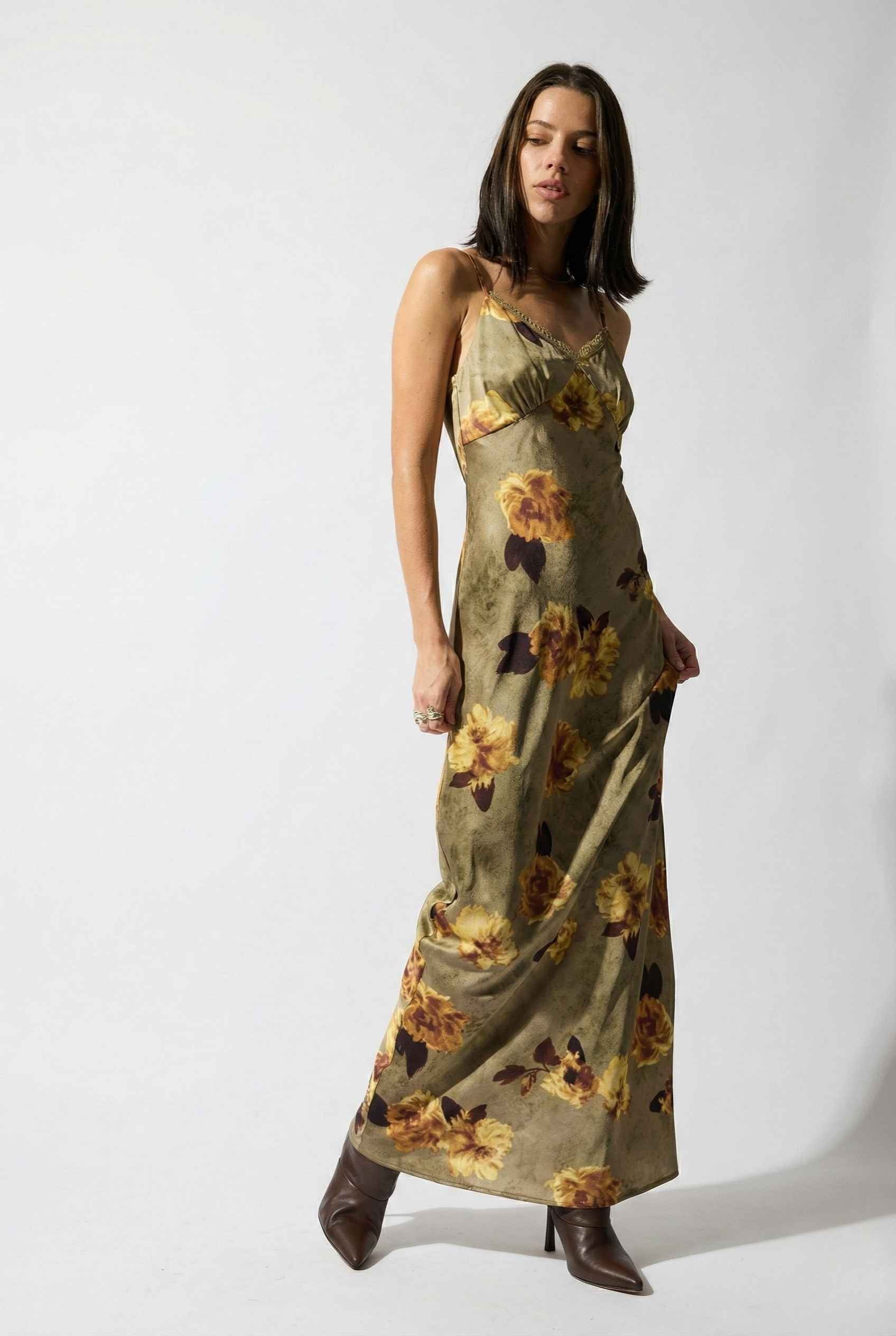 Woman wearing a Marcella Maxi Olive Floral Satin Slip Dress on a white background