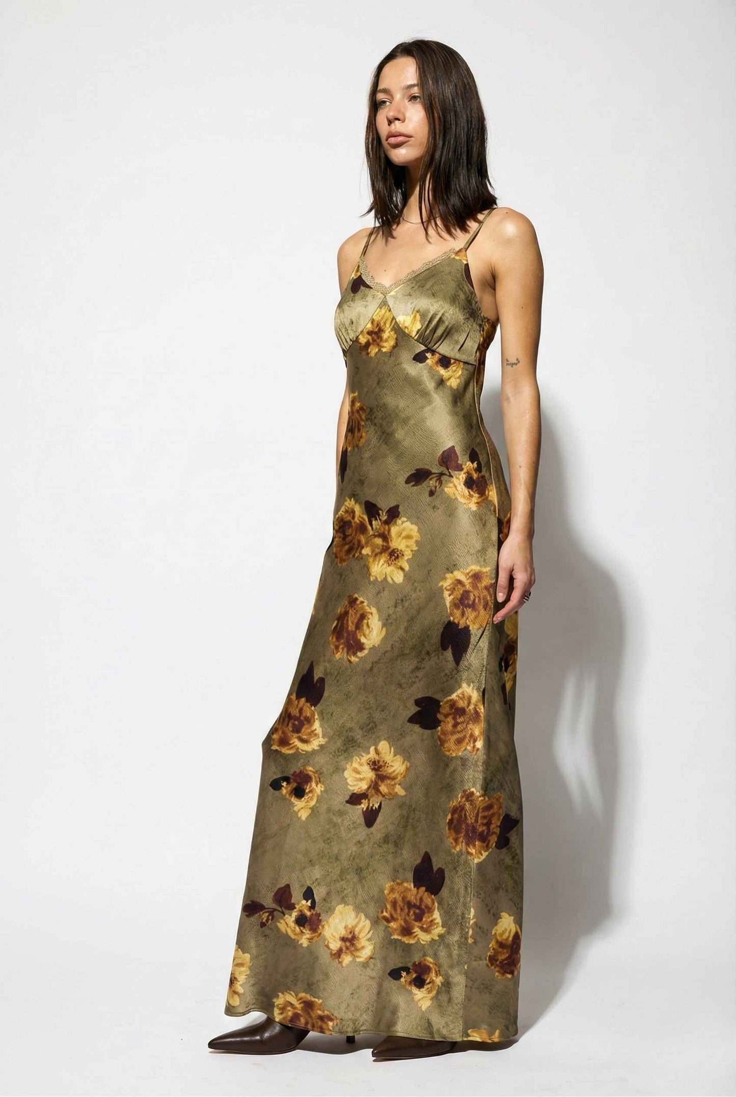 Woman wearing a Marcella Maxi Olive Floral Satin Slip Dress against a white background