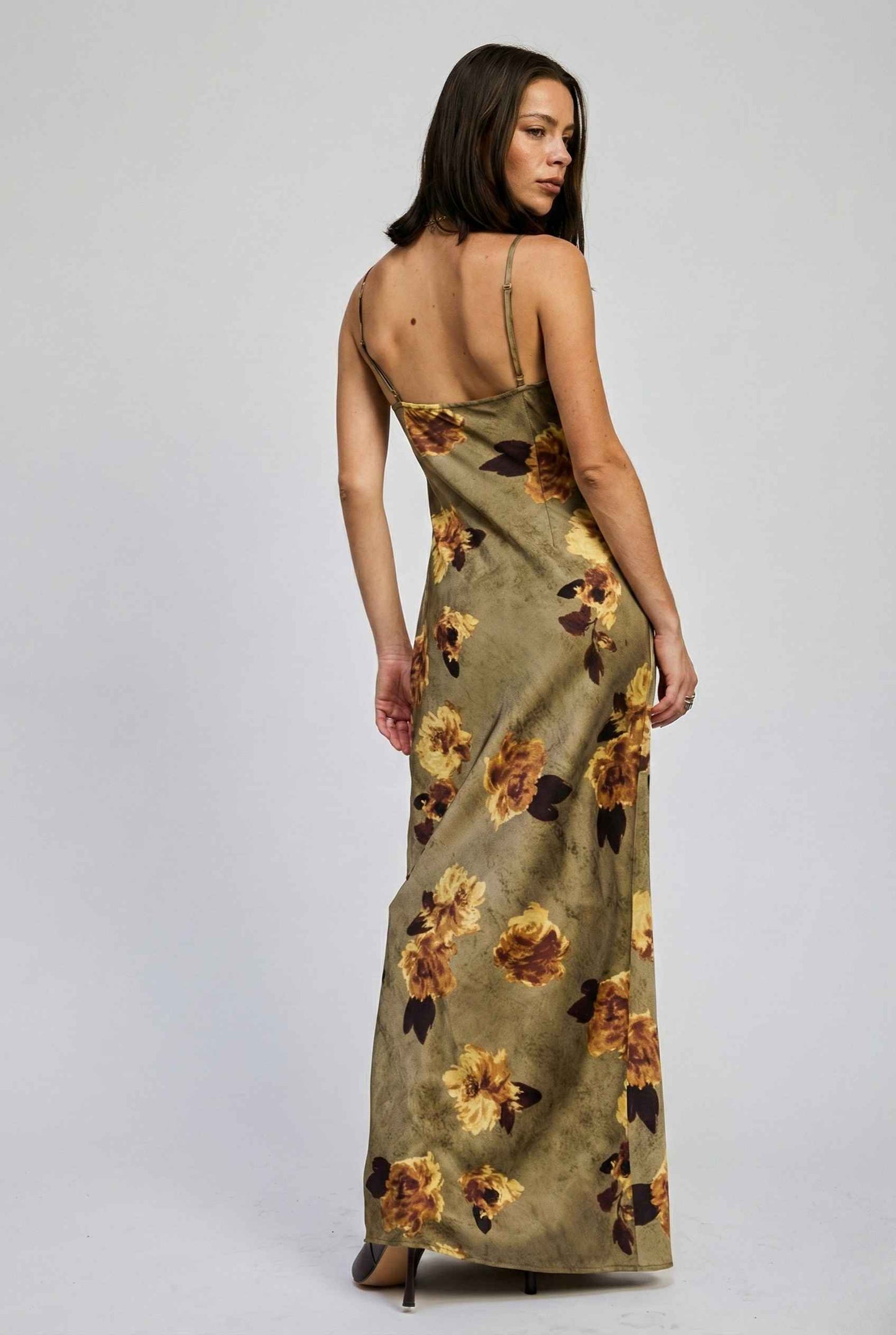 Woman wearing a Marcella Maxi Olive Floral Satin Slip Dress on a plain background