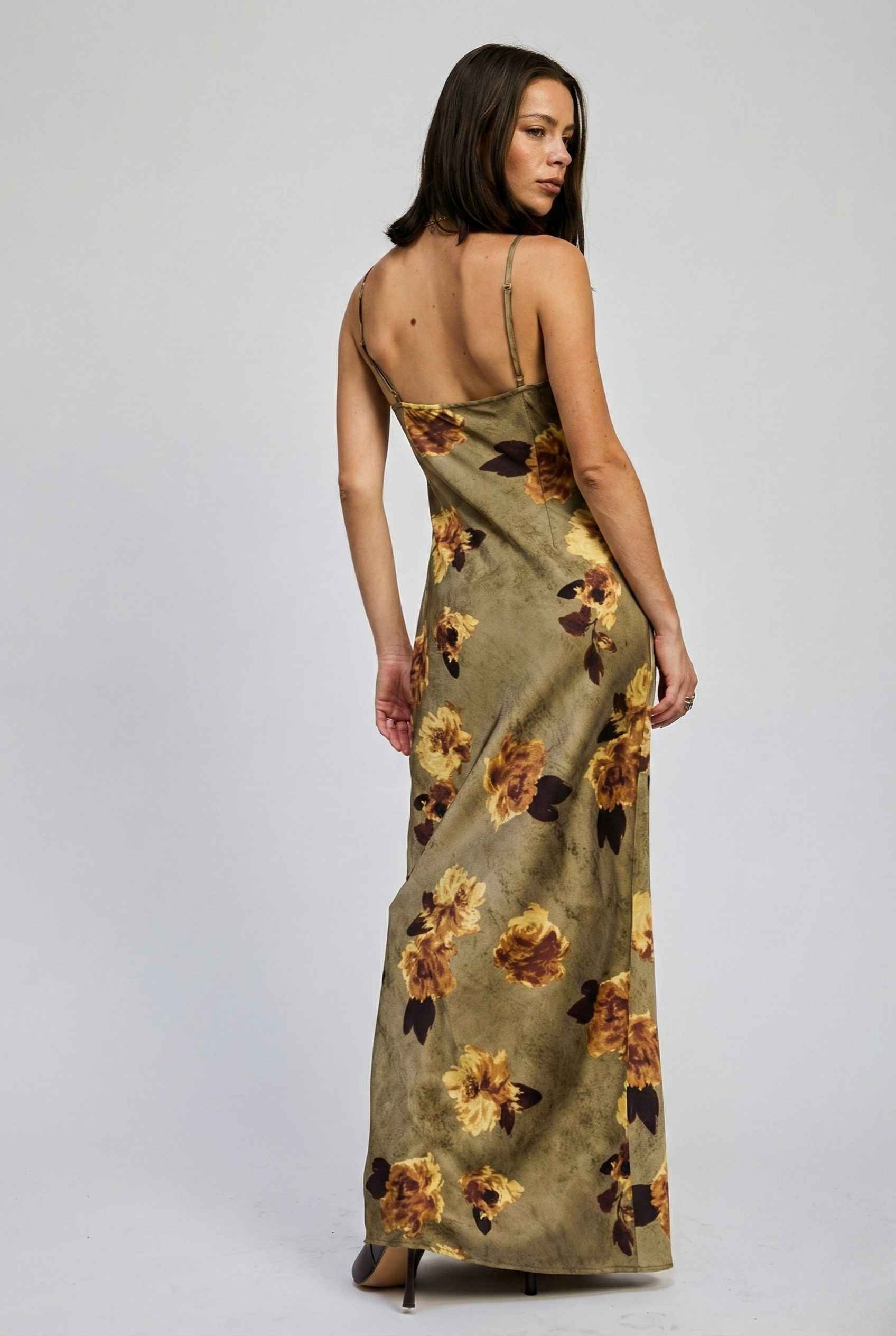 Woman wearing a Marcella Maxi Olive Floral Satin Slip Dress on a plain background