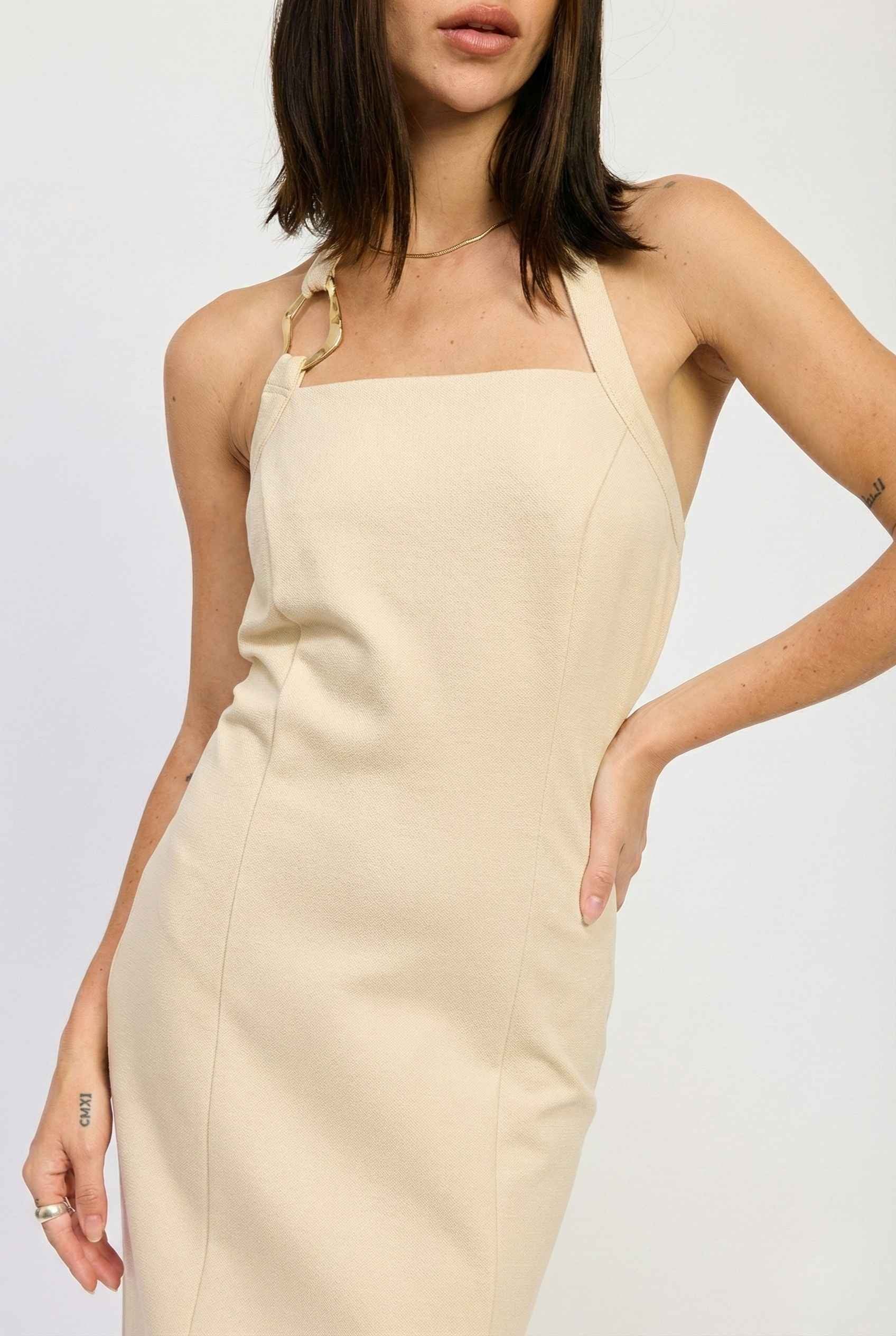 Woman wearing a Mercer Midi Taupe Halter Hardware Dress against a plain background