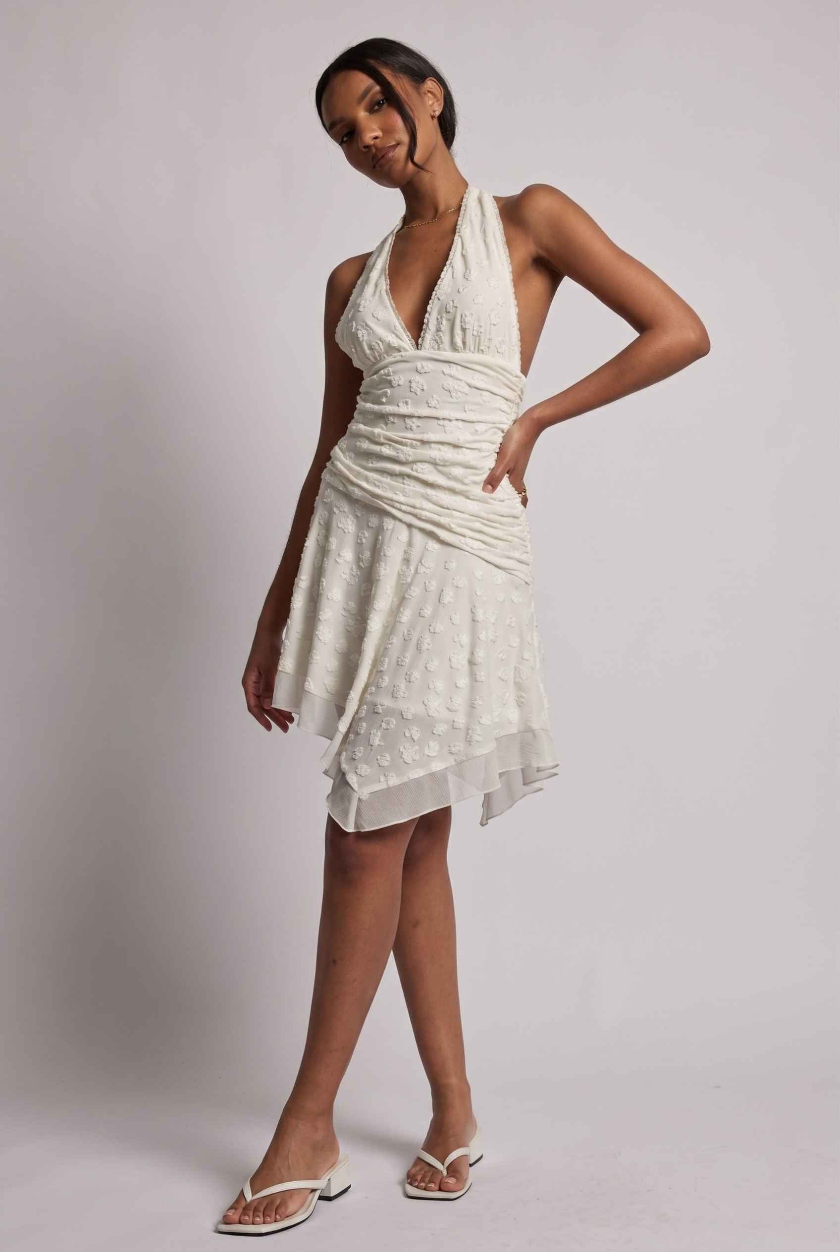 Model wearing Mikala Ruched Halter Mini Dress in Ivory Cocktail Dress paired with minimalist heels