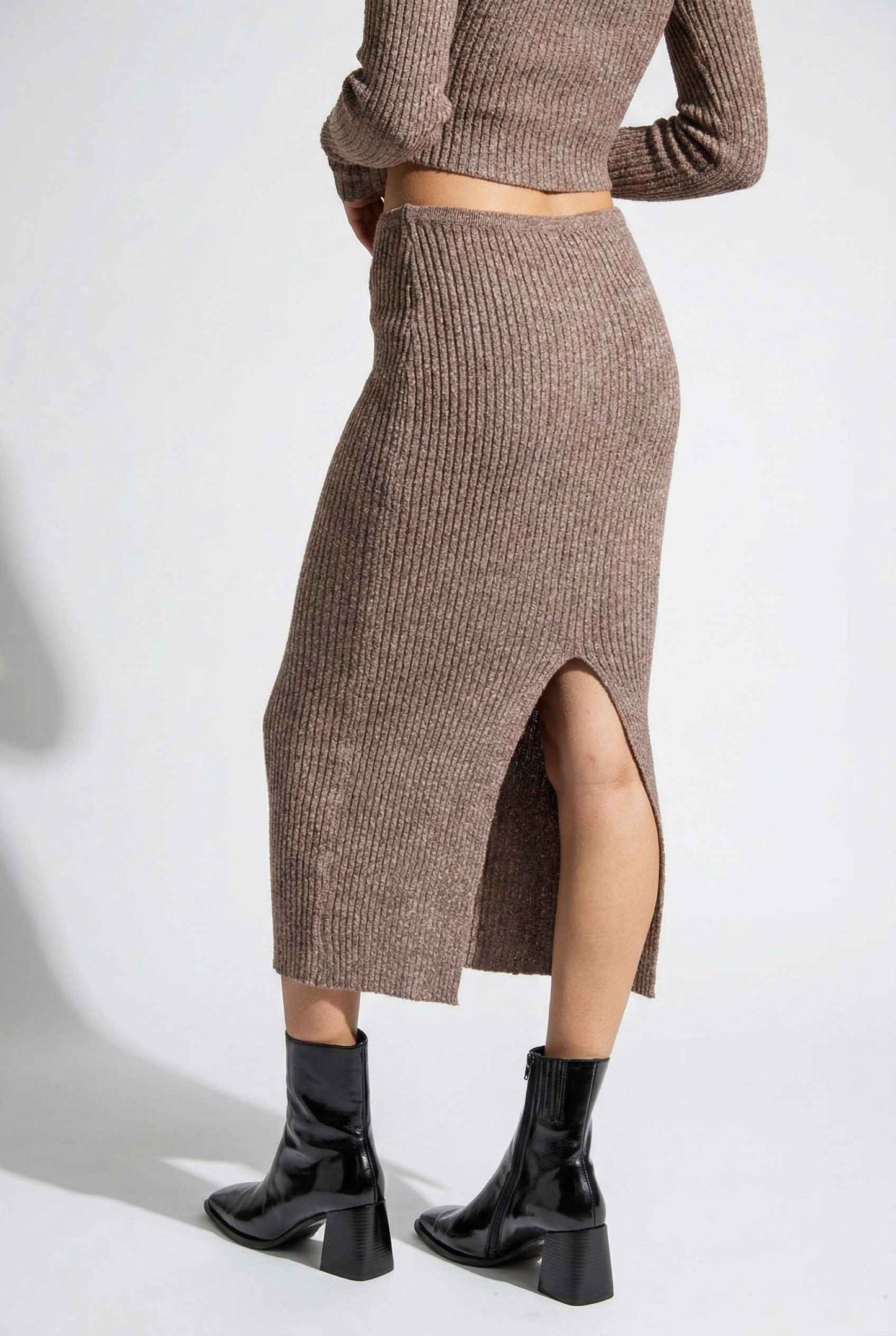 Model wearing Mila Skirt Marled Ribbed Knit Column Maxi Skirt in Brown with matching sweater top and heeled boots on a plain background
