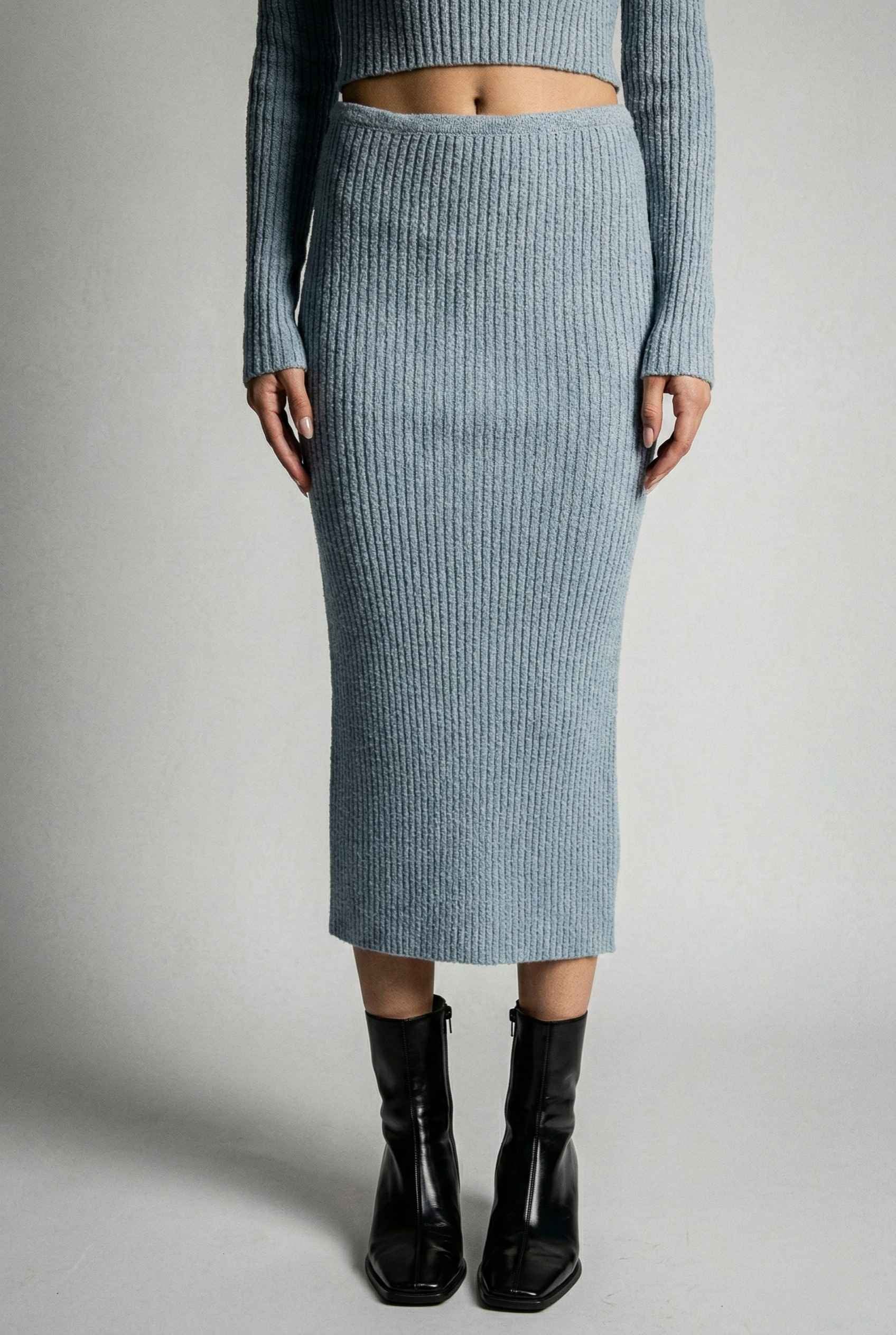 Model wearing Mila Skirt Marled Ribbed Knit Column Maxi Skirt in Light Blue with matching sweater top and heeled boots on a plain background