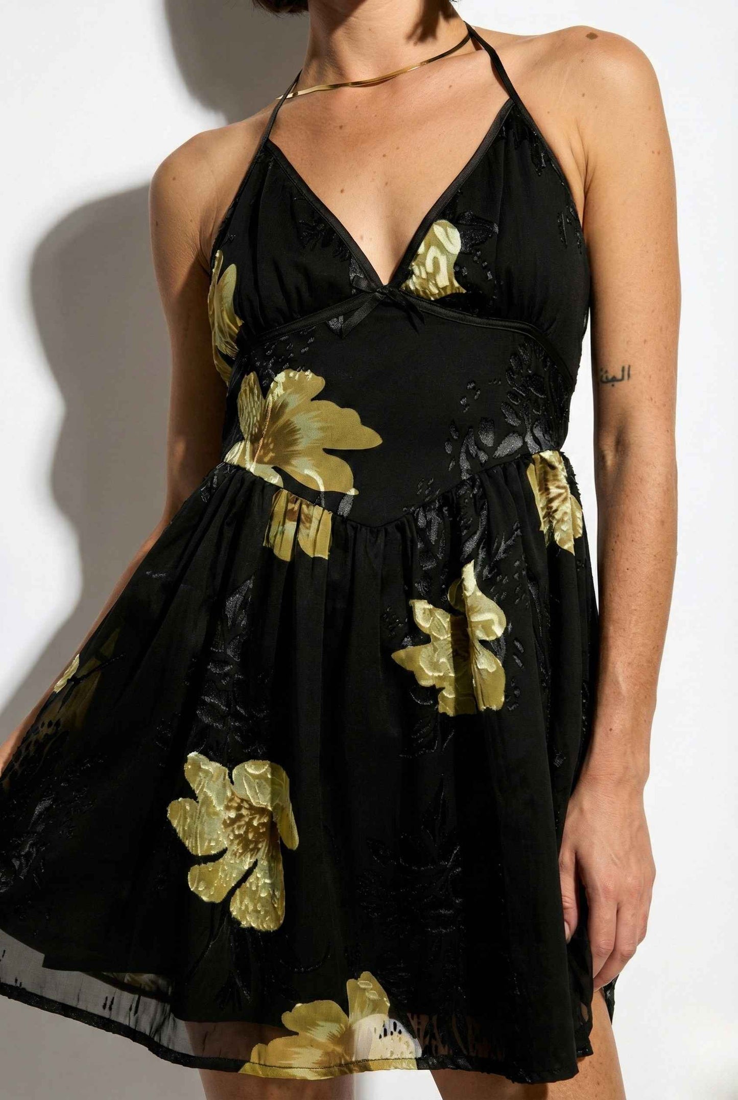 Nina Mini Black & Gold Floral Halter Dress with gold floral patterns on a white background
