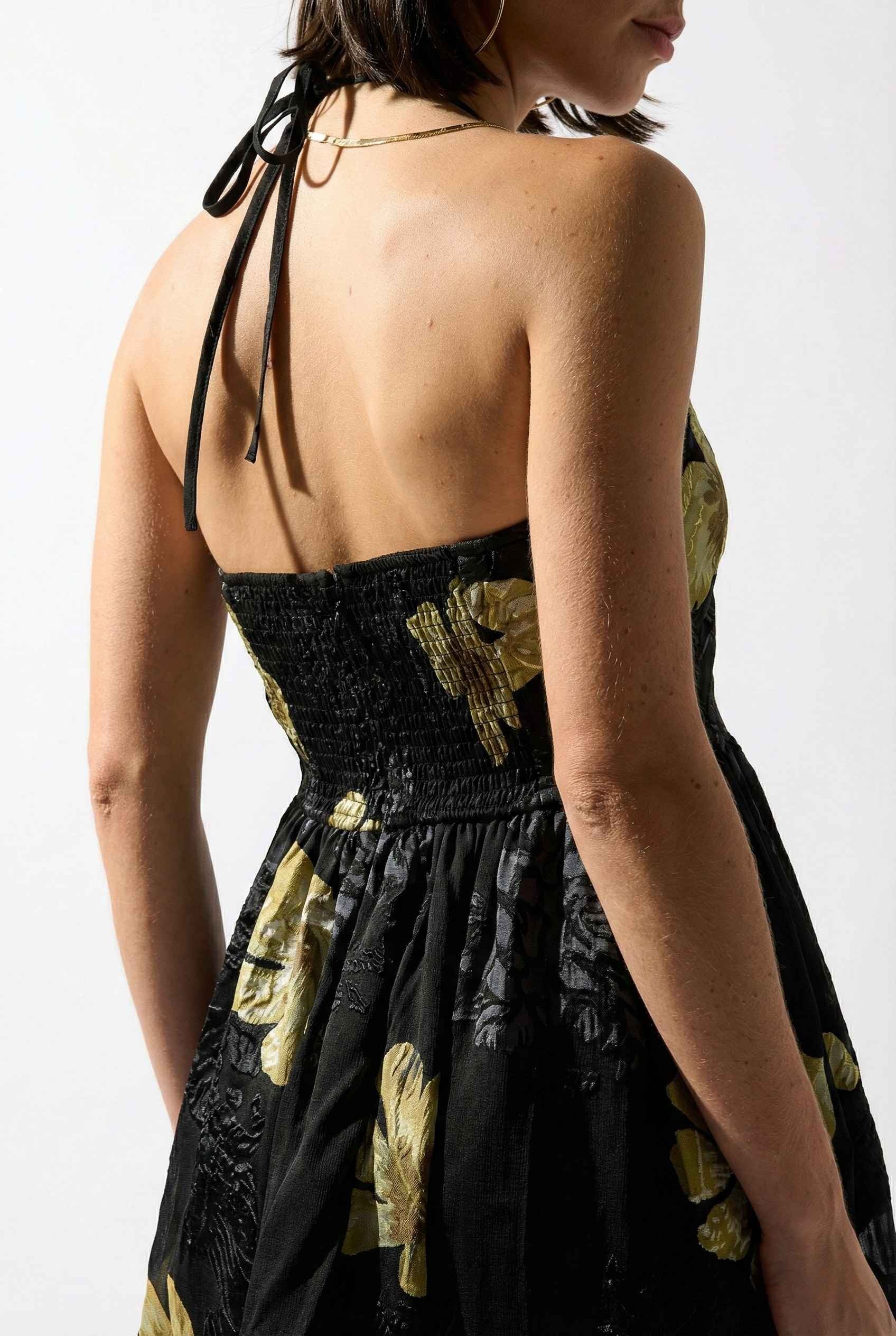Nina Mini Black & Gold Floral Halter Dress with gold floral patterns on a white background