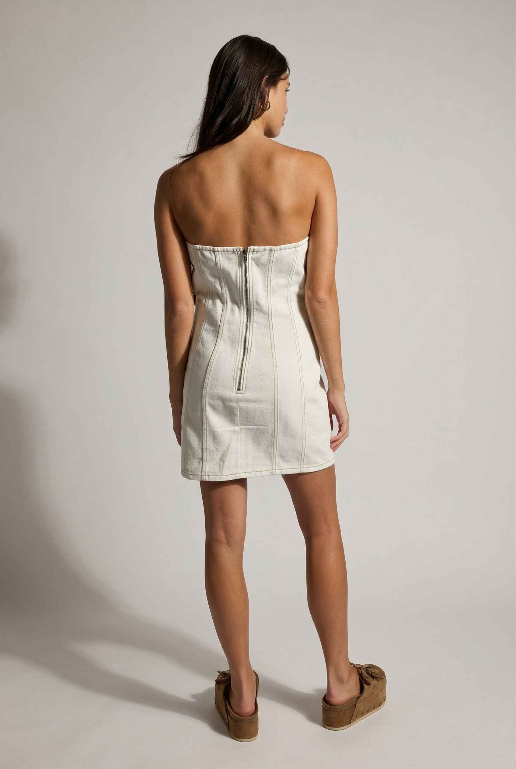Model wearing Odette Mini in White Denim Strapless Rosette Dress with platform sandals